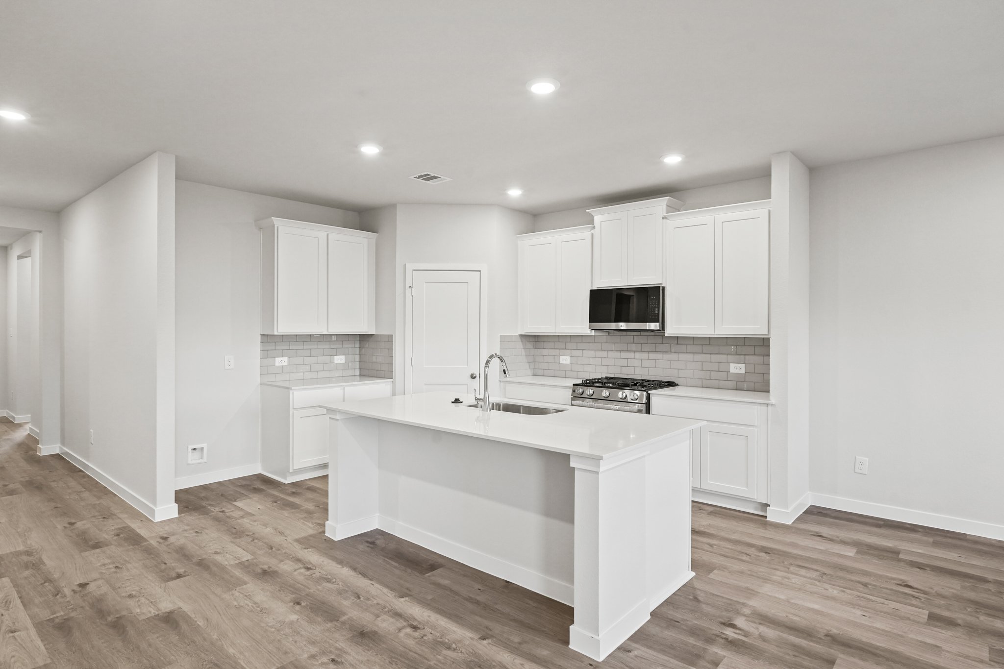 A kitchen with white cabinets.