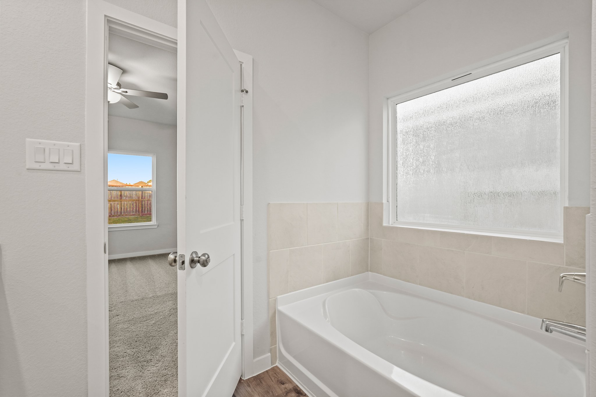 A bathroom with a bathtub and a window.