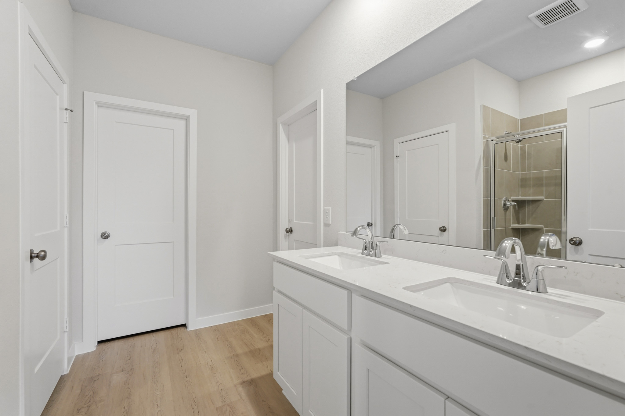 A bathroom with white cabinets.