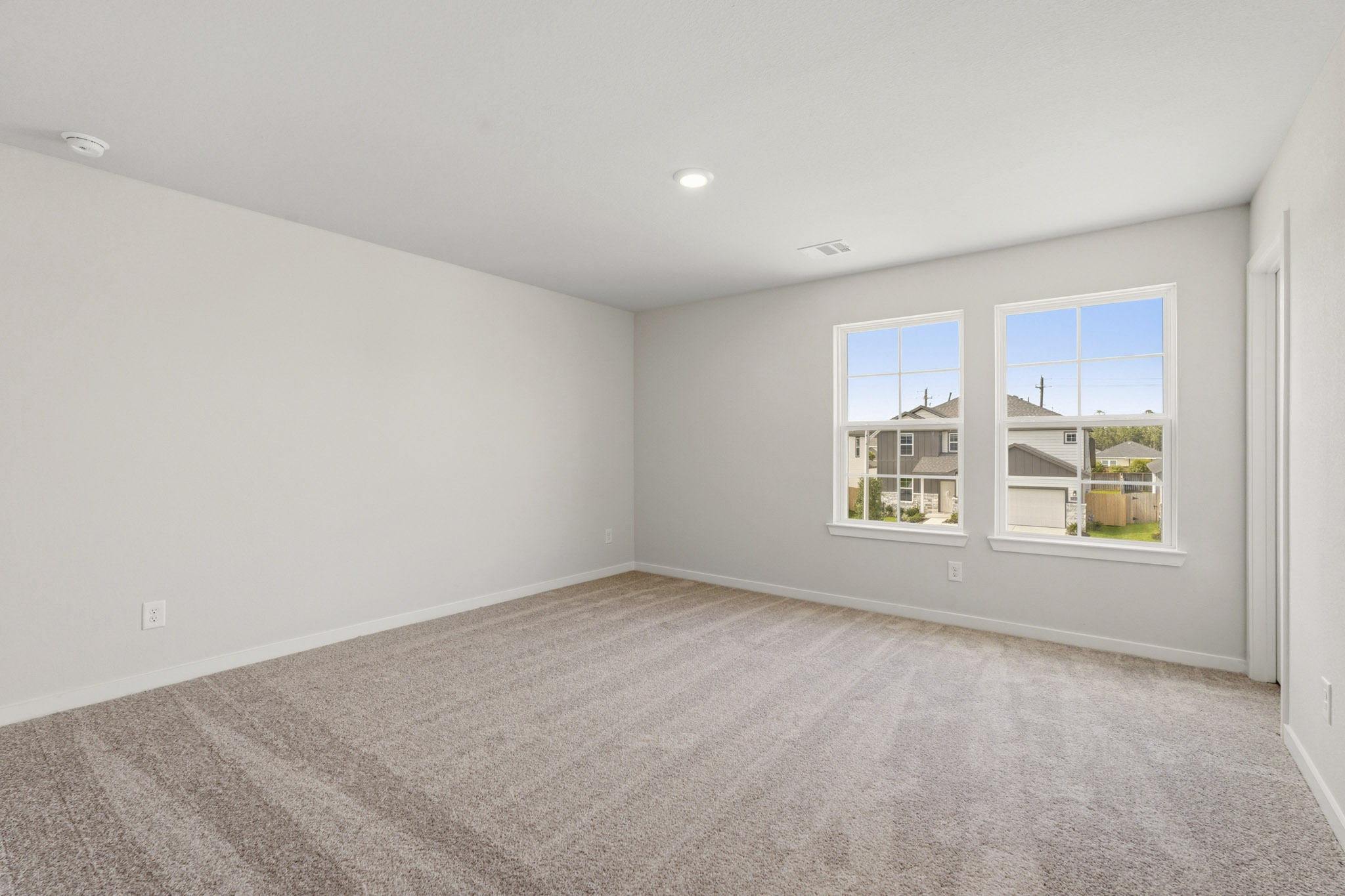 A room with a carpet and windows.