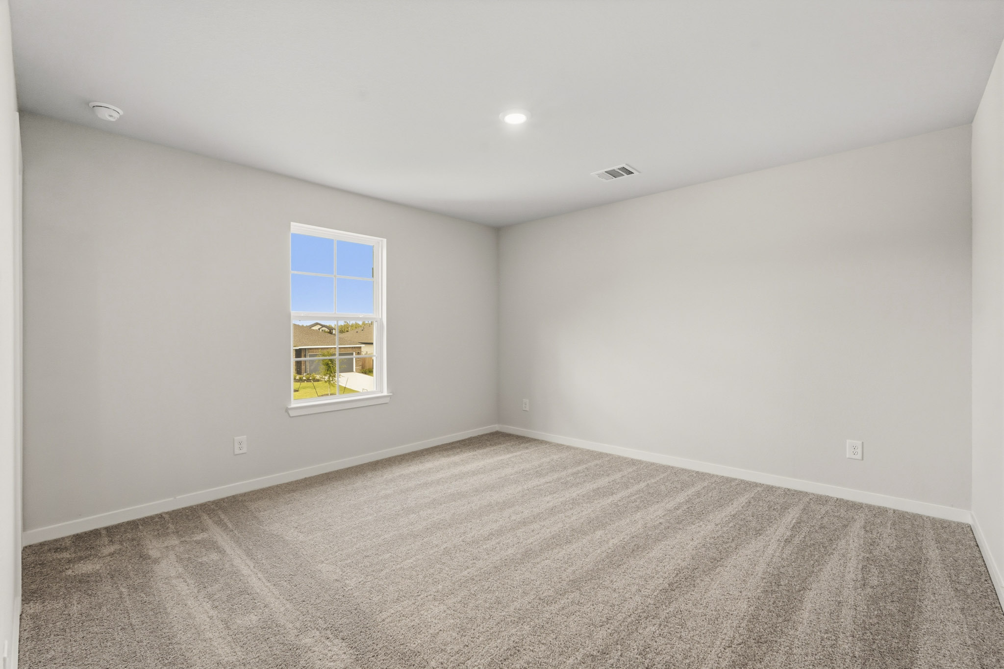 A room with a window and a carpet.