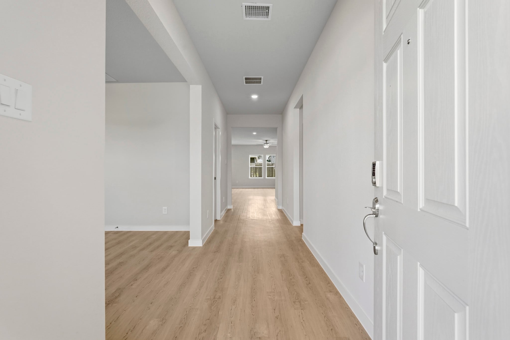 A long hallway with white doors.