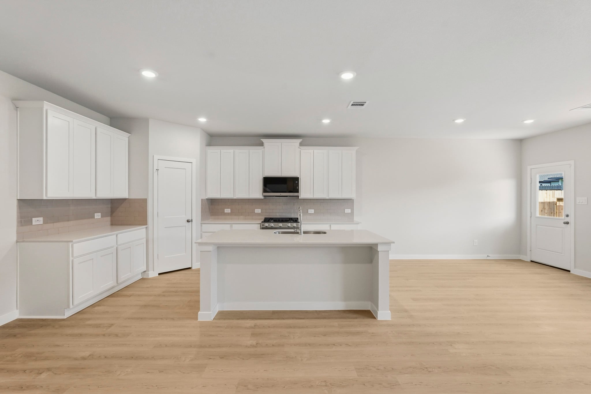 A kitchen with white cabinets.