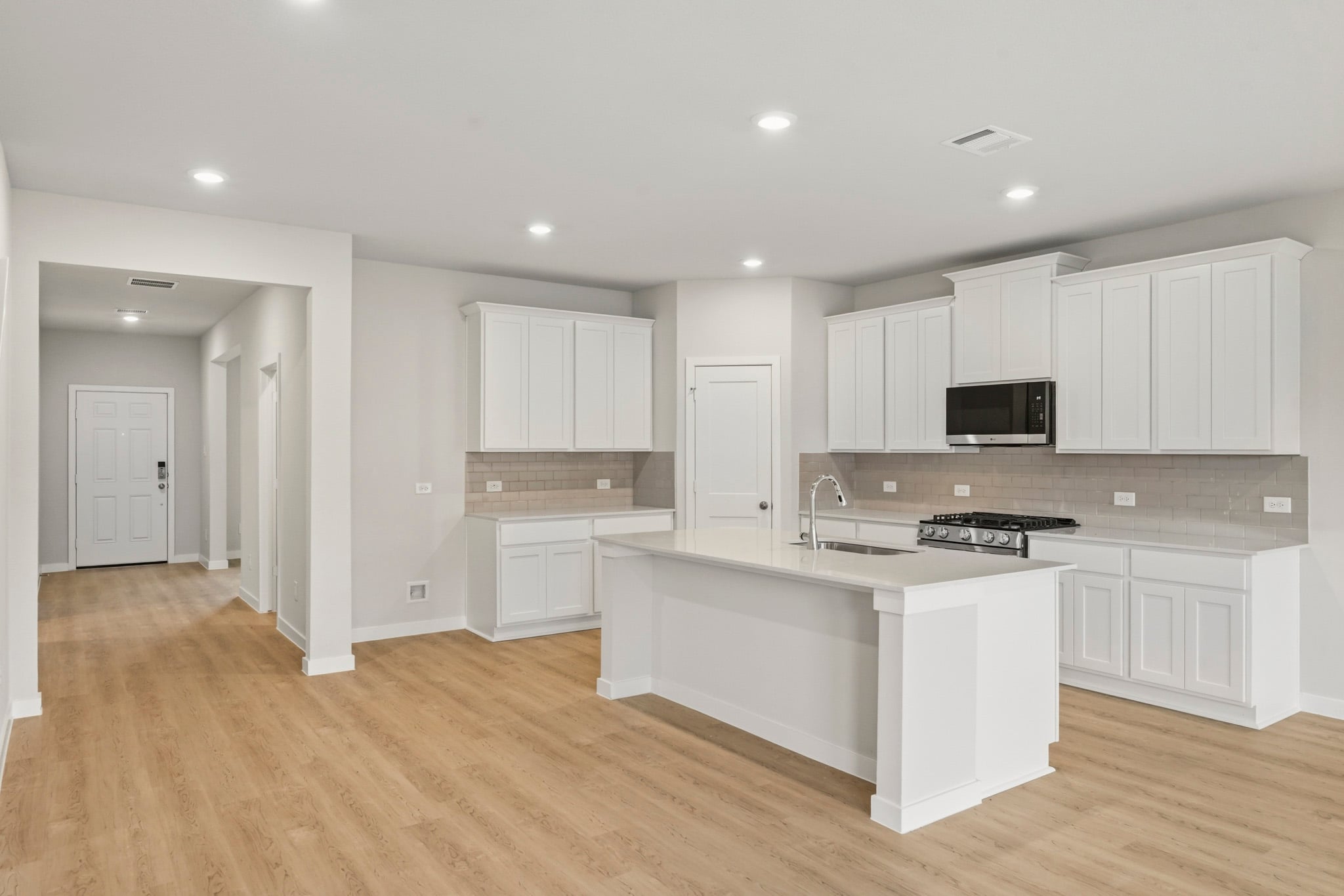 A kitchen with white cabinets.