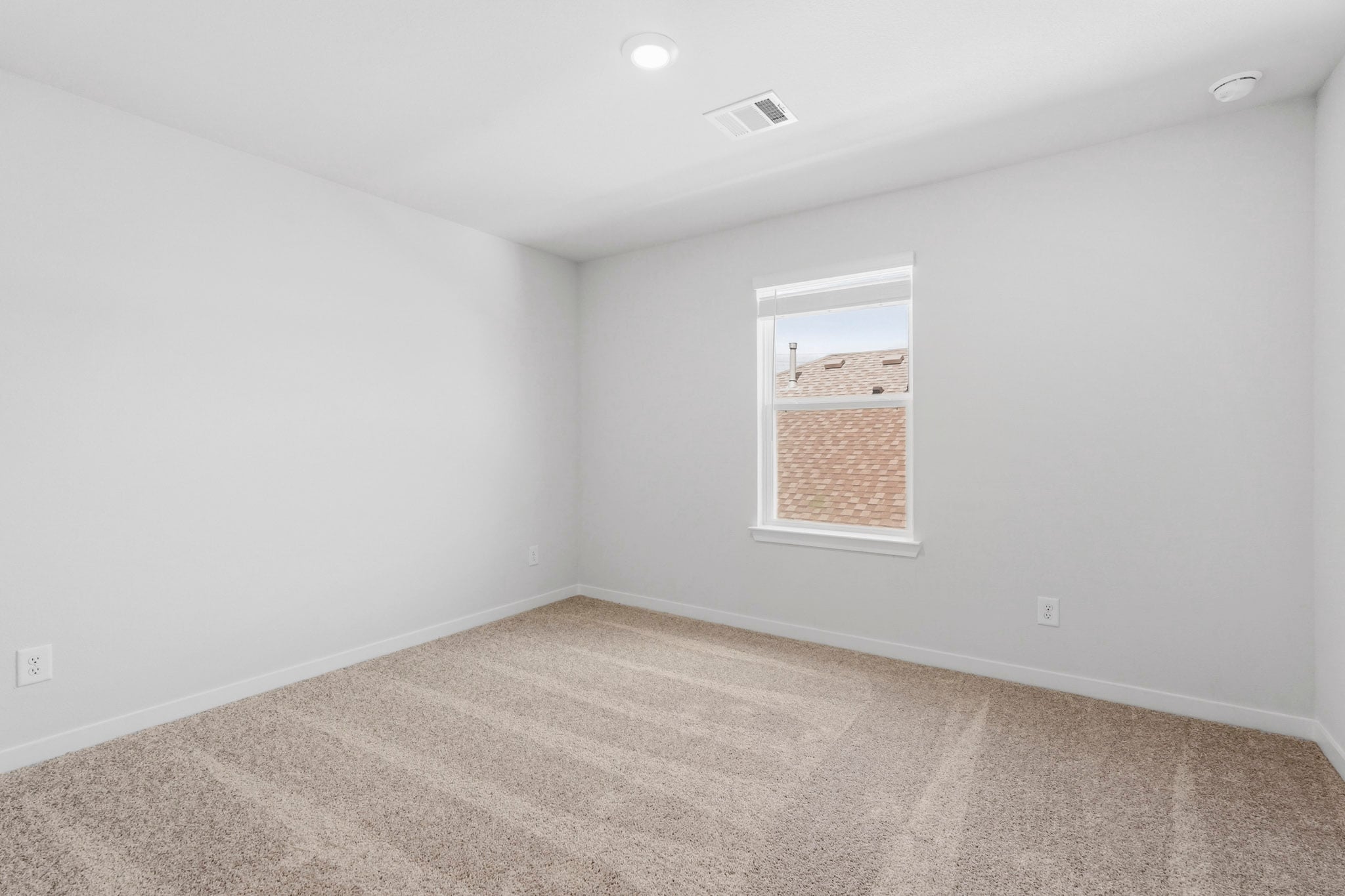 A room with a window and a carpet.