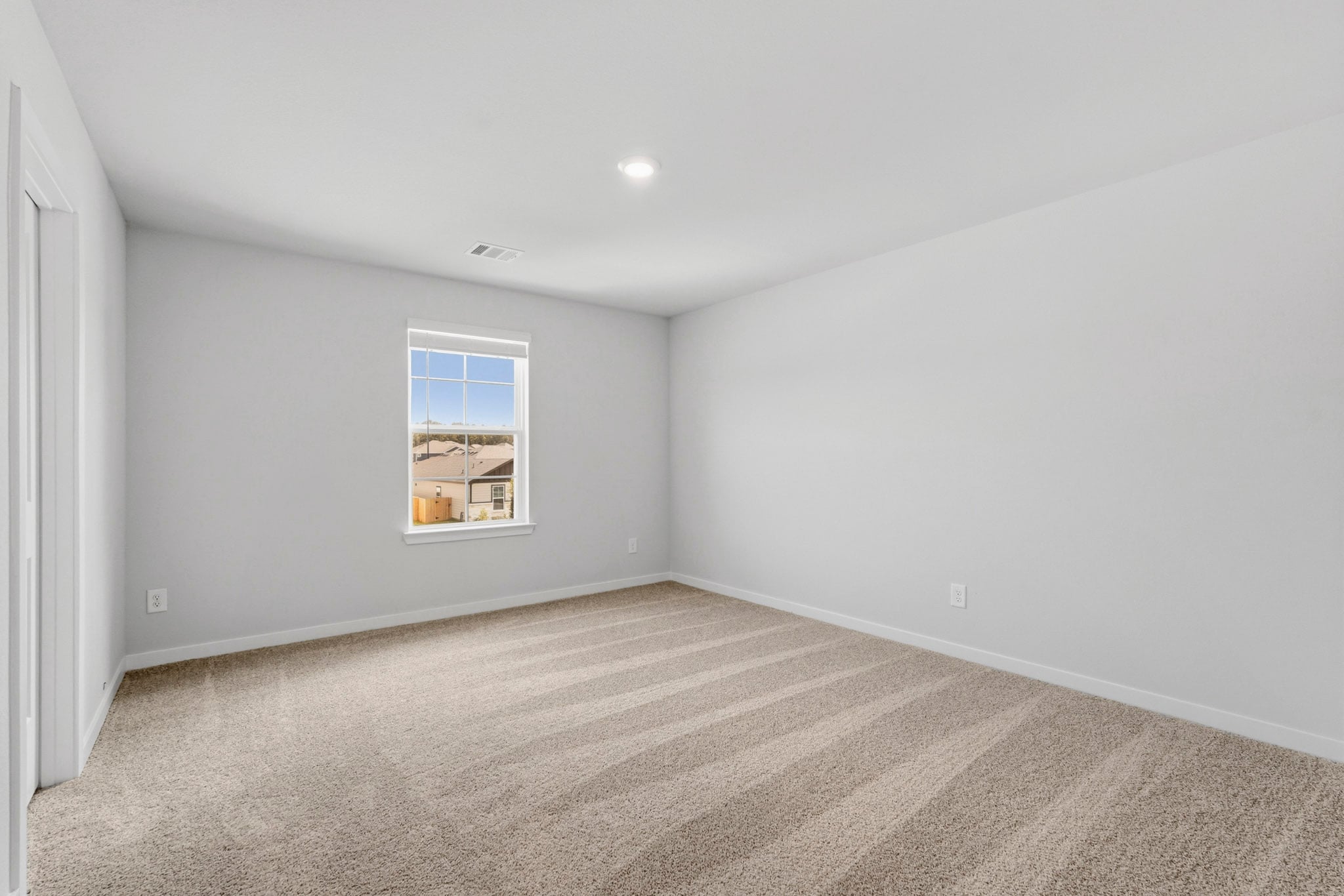 A room with a window and carpet.