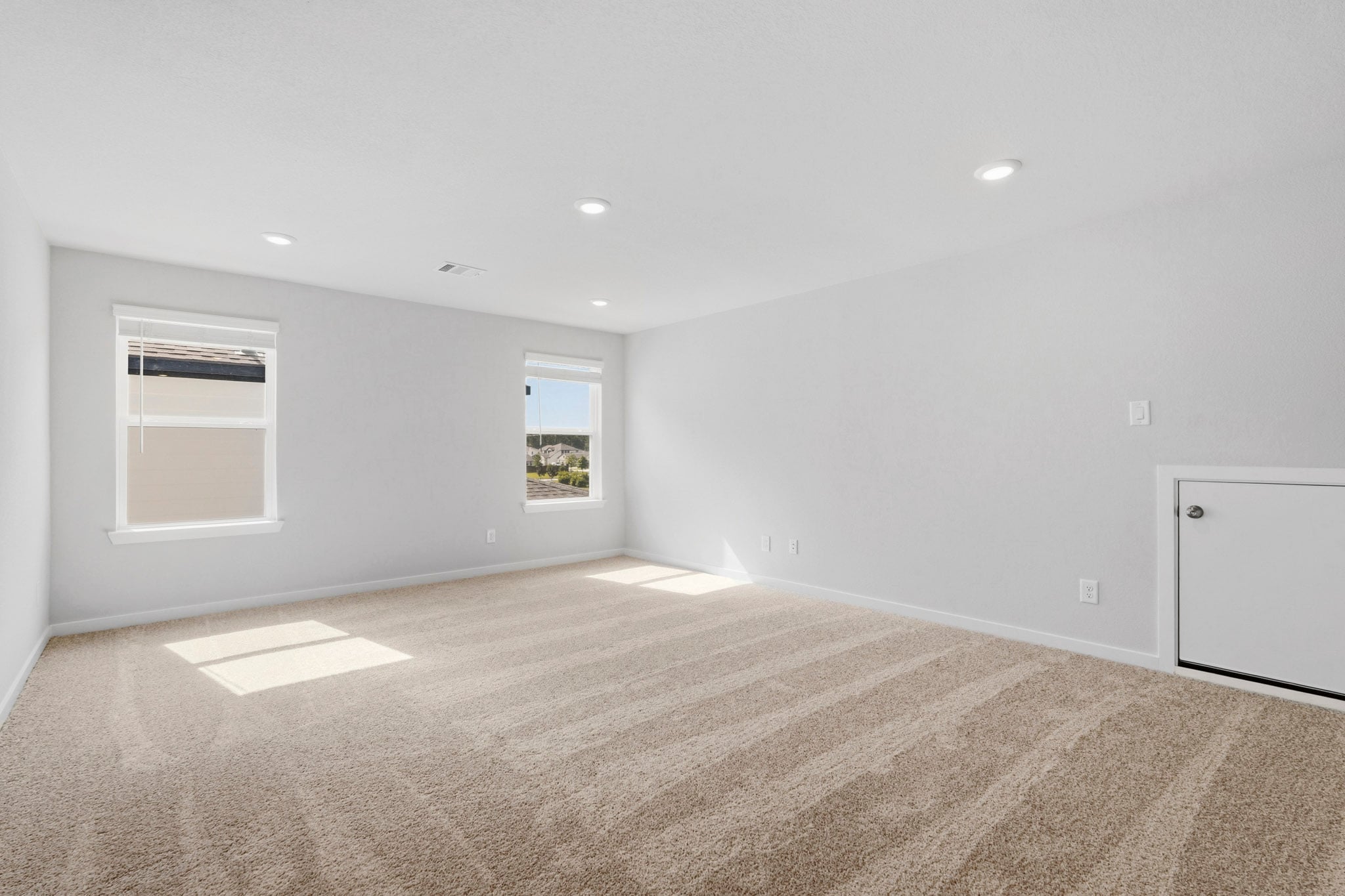 A room with a carpet and windows.