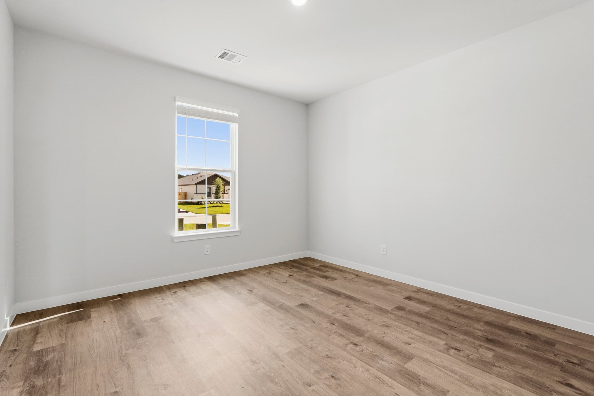 A room with a wood floor and a window.