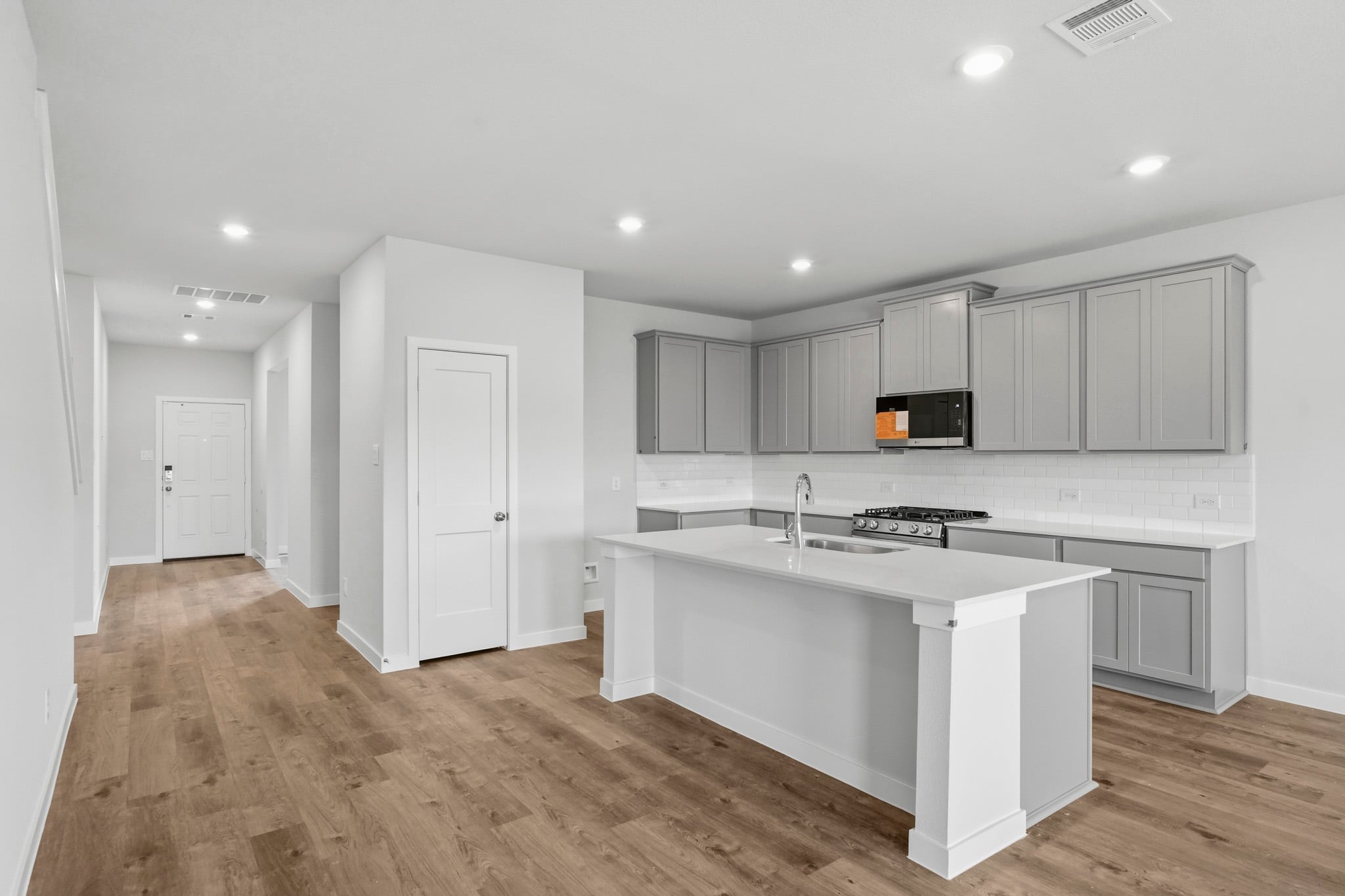 A kitchen with white cabinets.