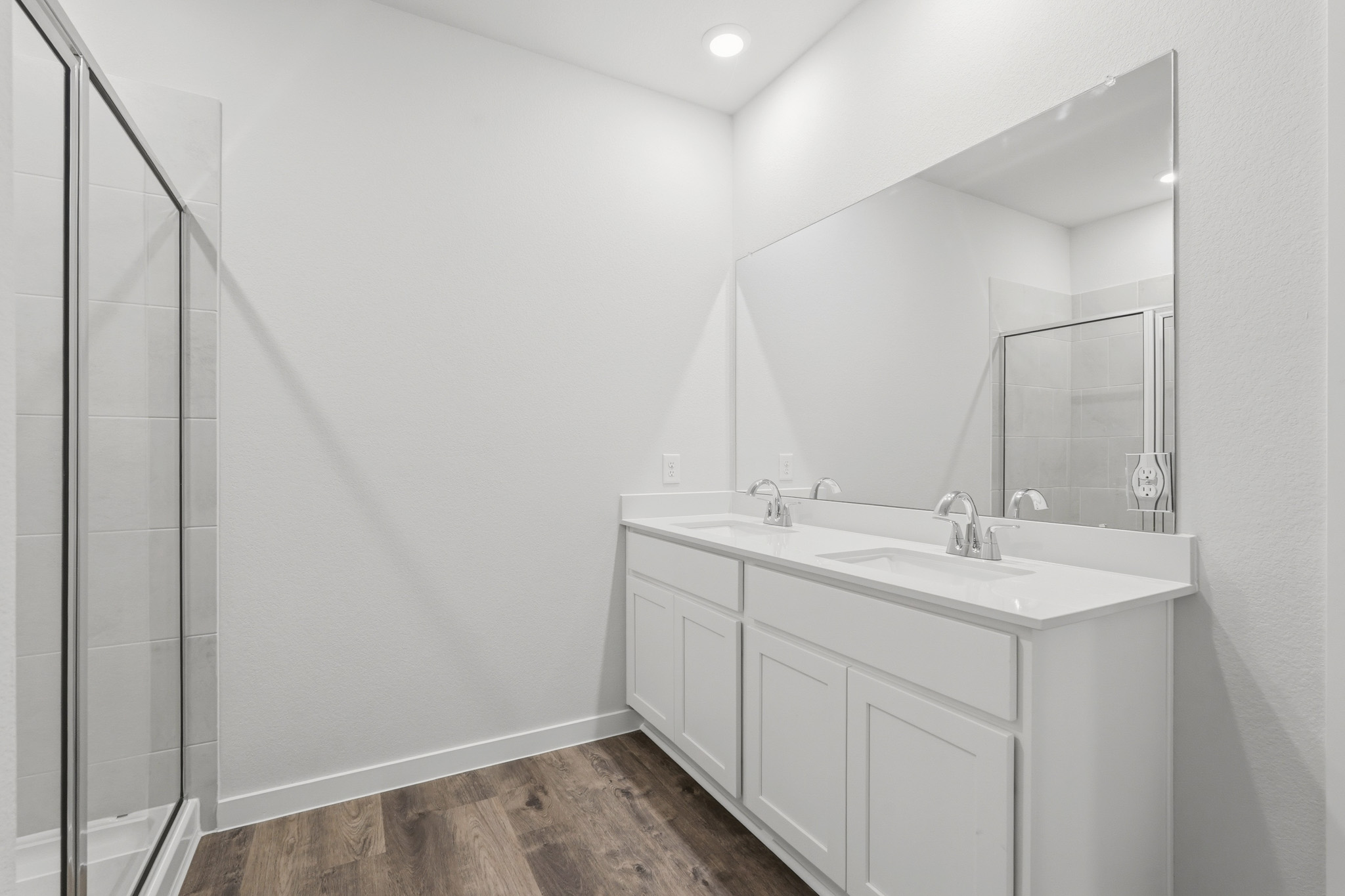 A bathroom with a sink and a shower unit.