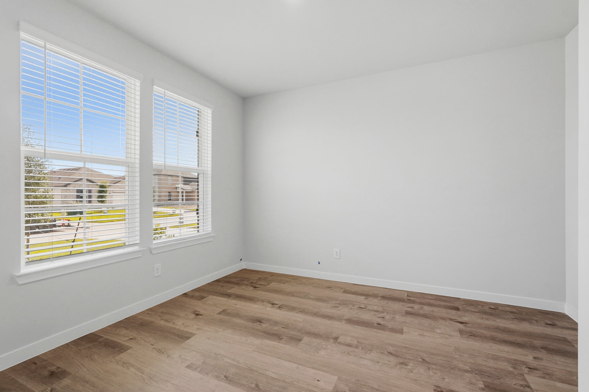 A room with a wood floor and windows.