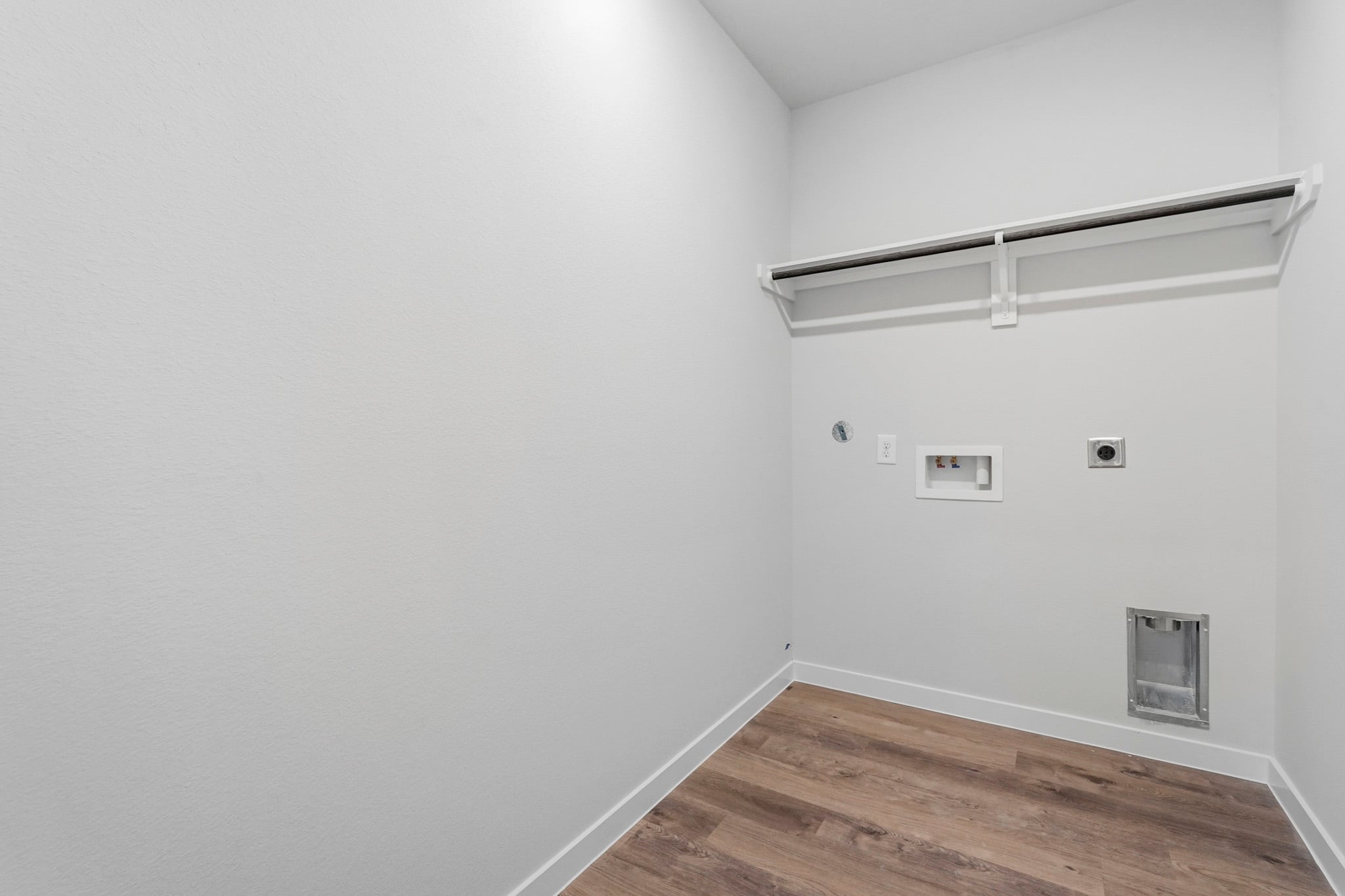 A white room with a wood floor.
