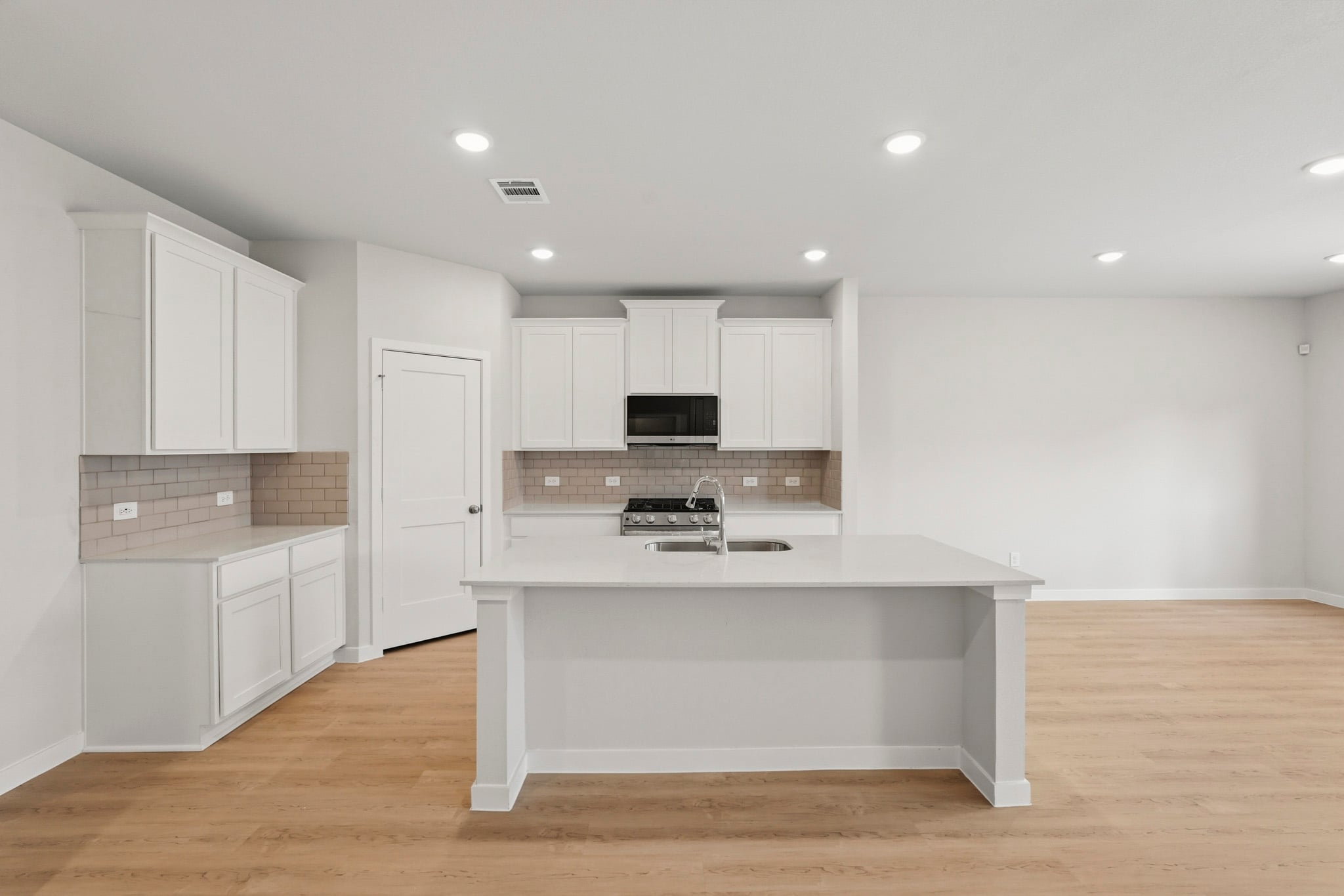 A kitchen with white cabinets.