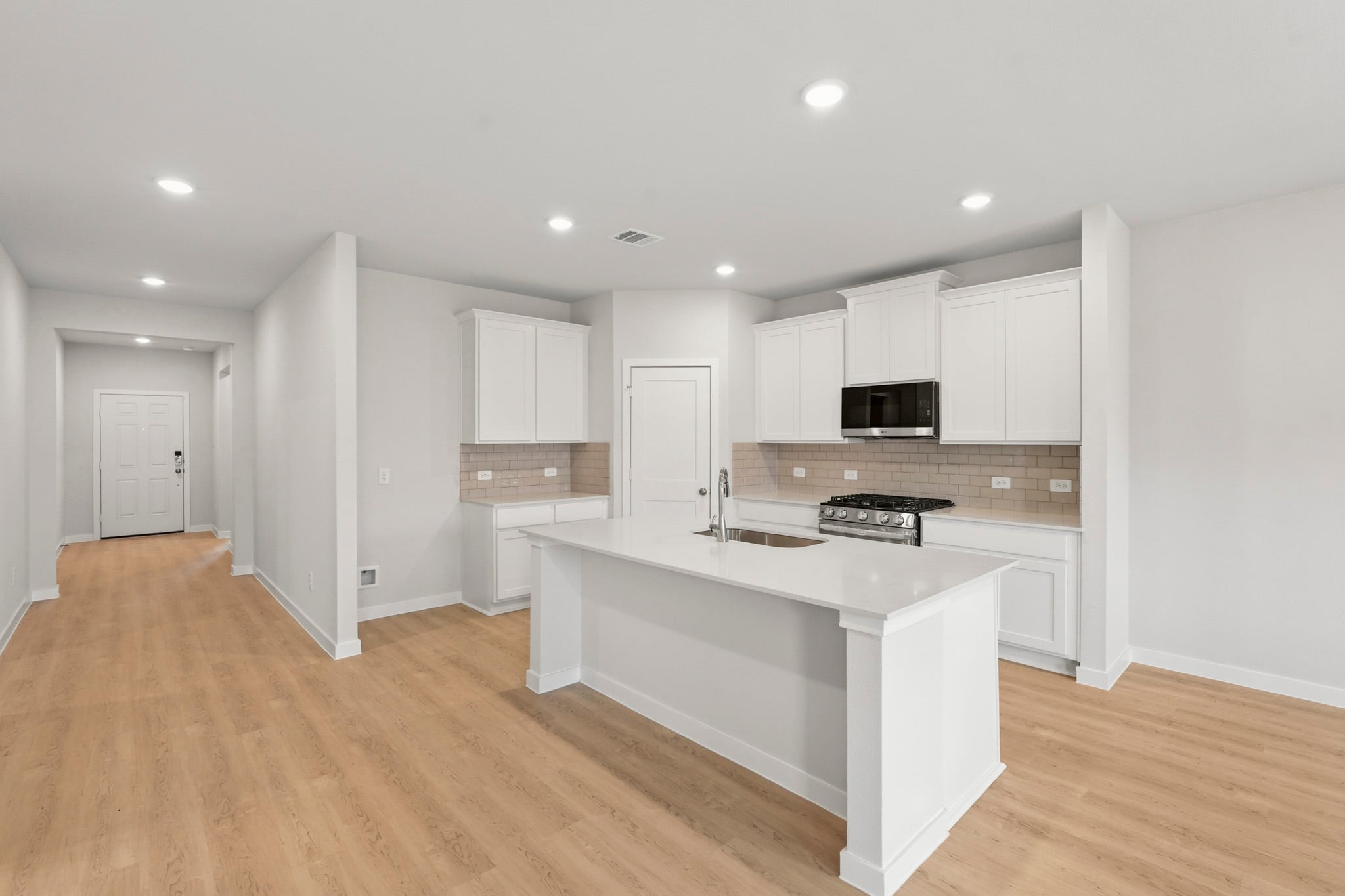 A kitchen with white cabinets.