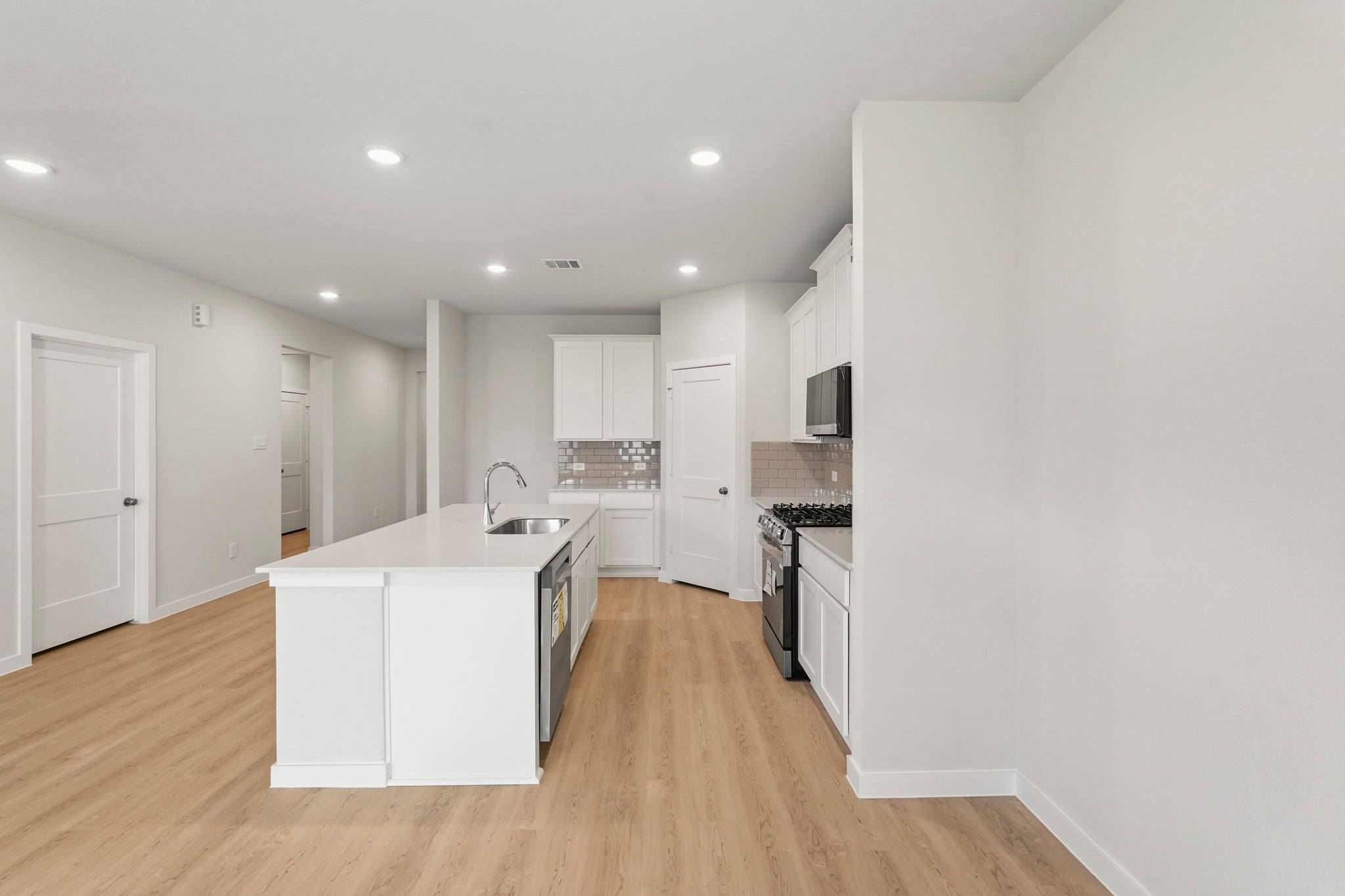 A kitchen with white cabinets.