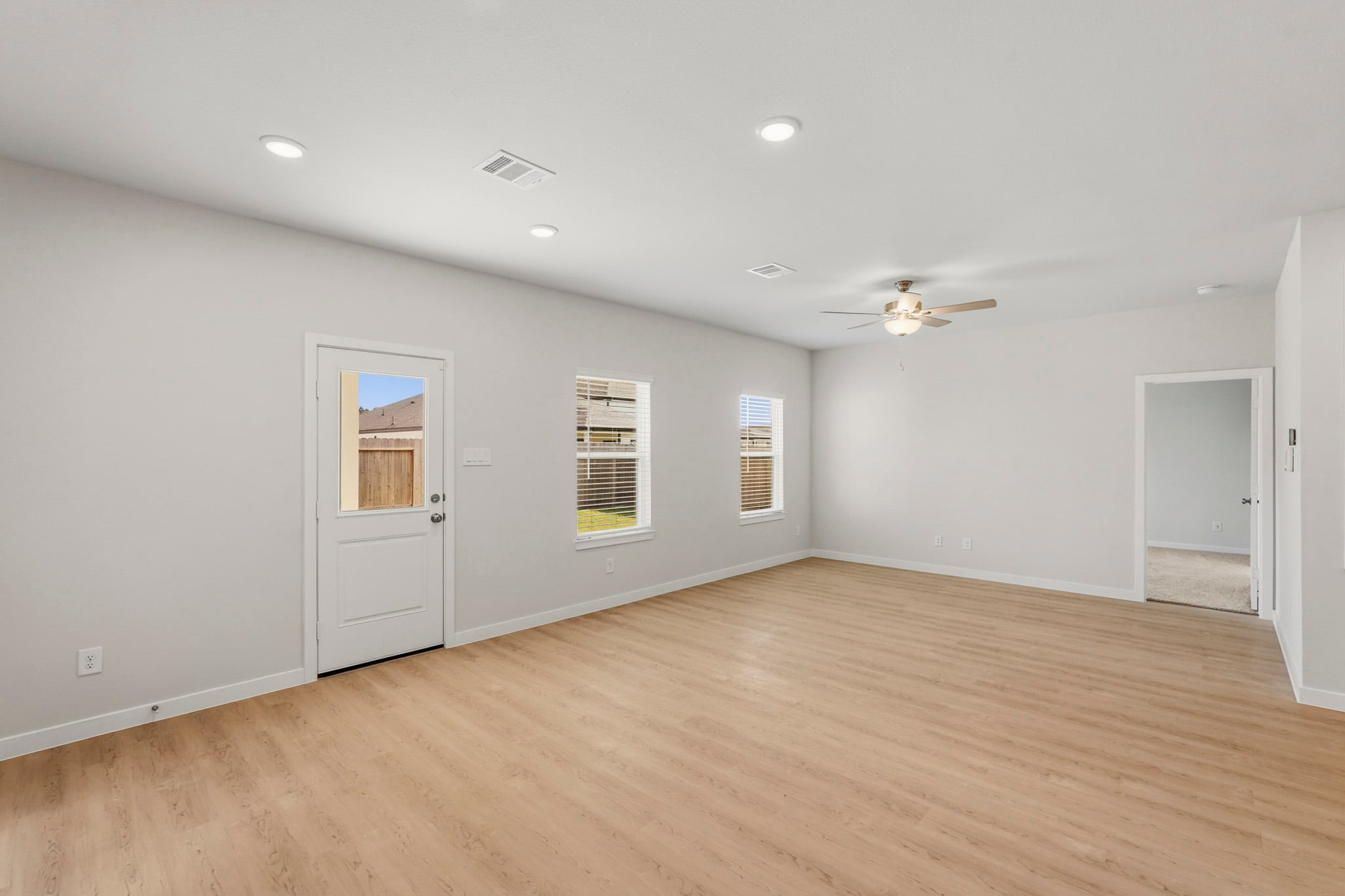 A room with a wood floor and a ceiling fan.