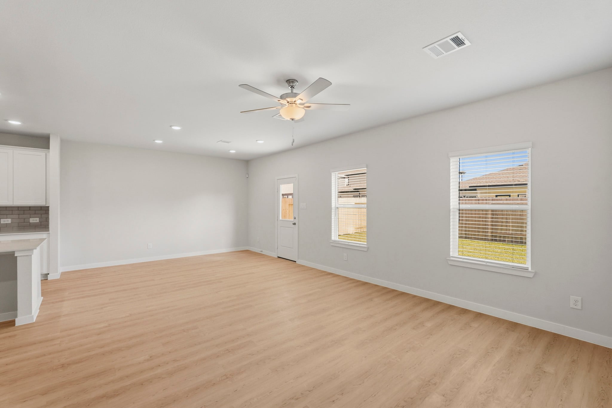 A room with a wood floor and a ceiling fan.