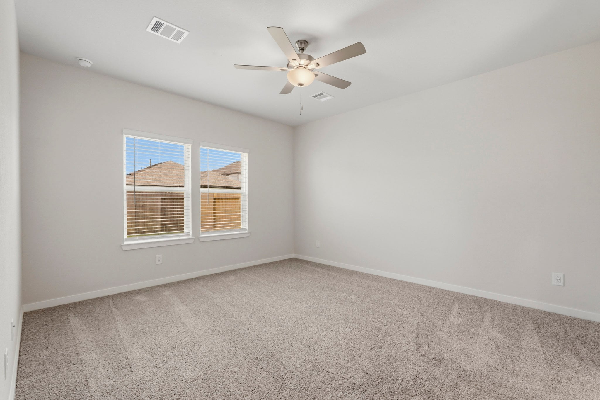 A room with a ceiling fan and a window.