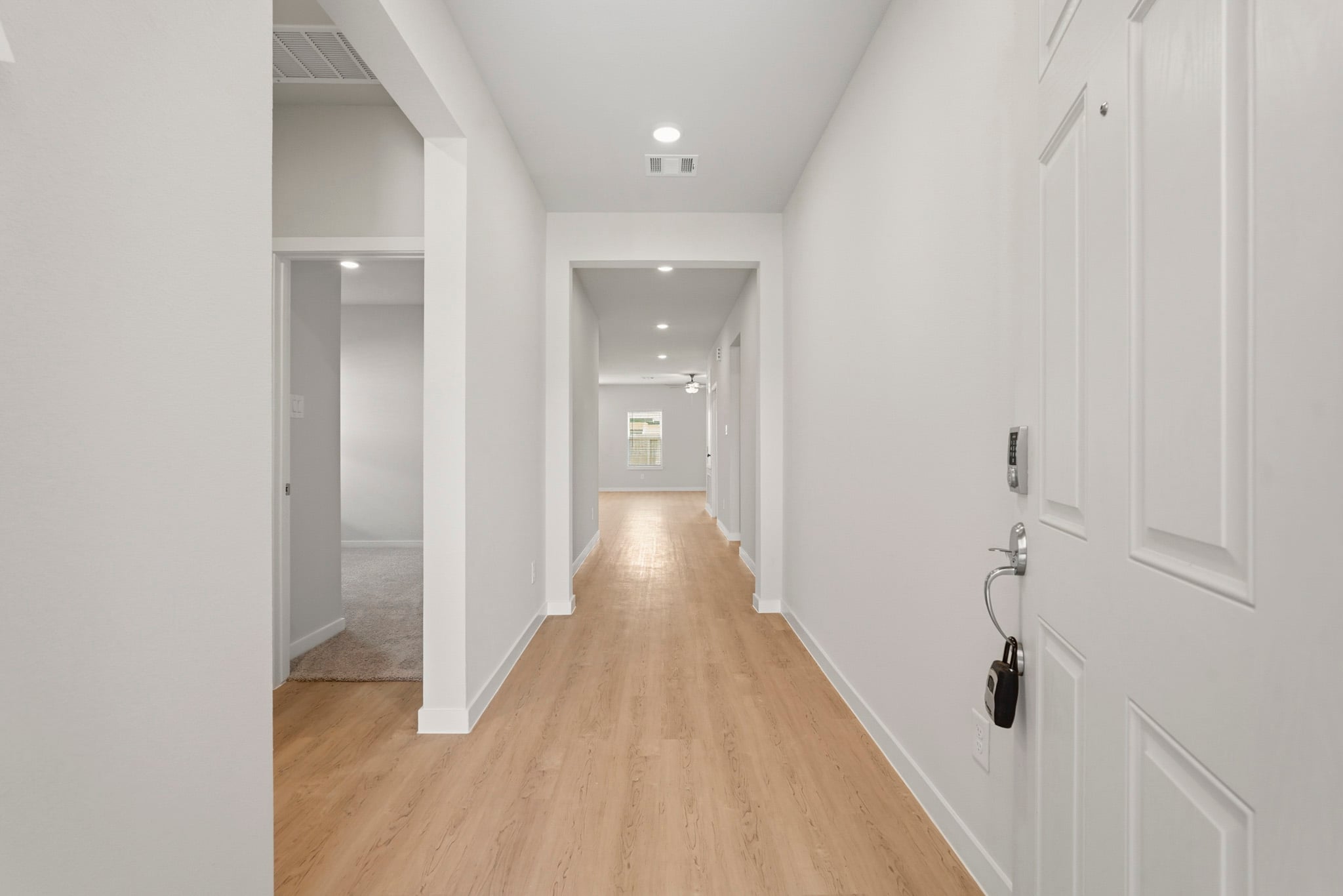 A long hallway with white doors.