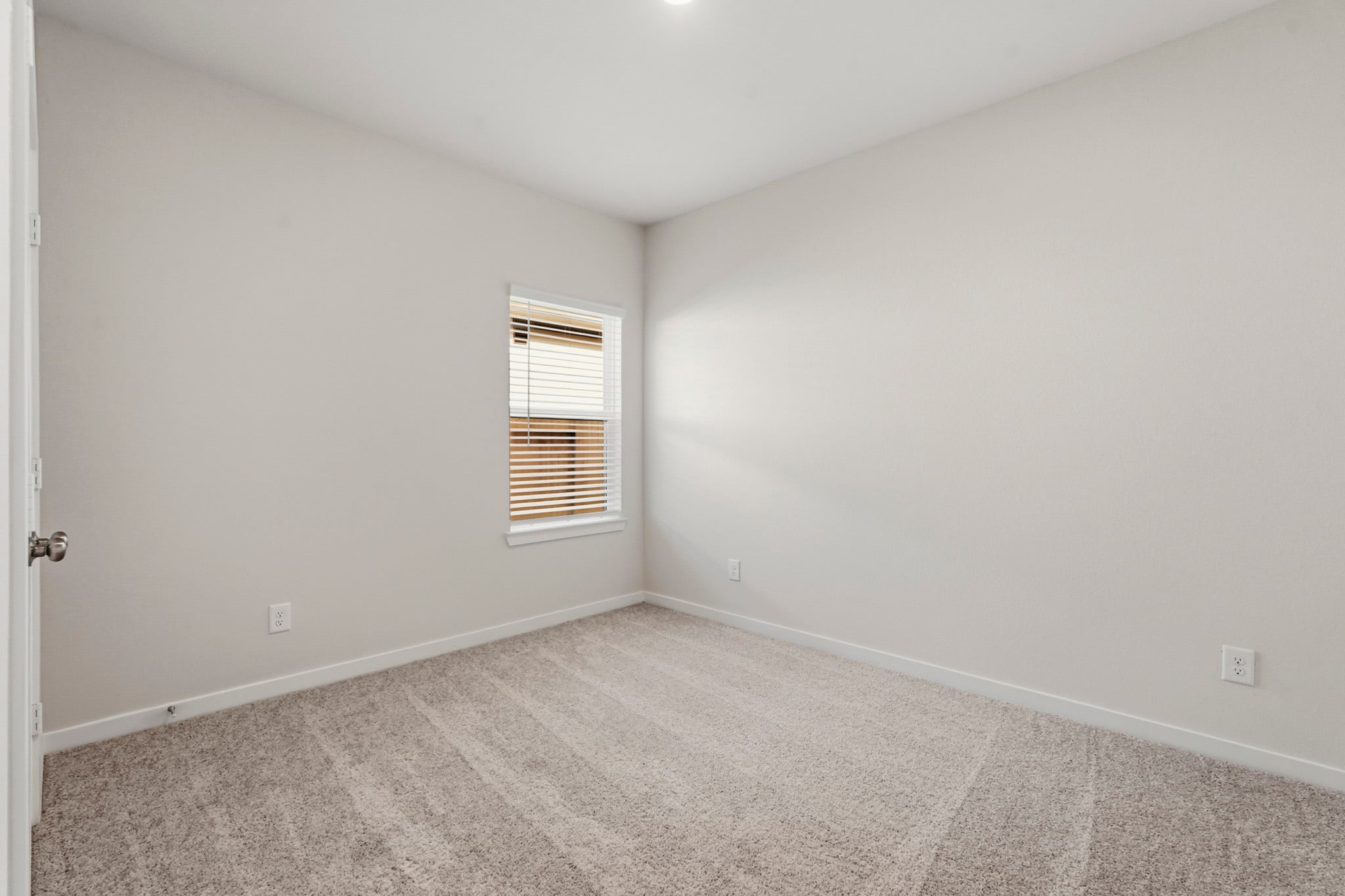 A room with a window and a carpet.