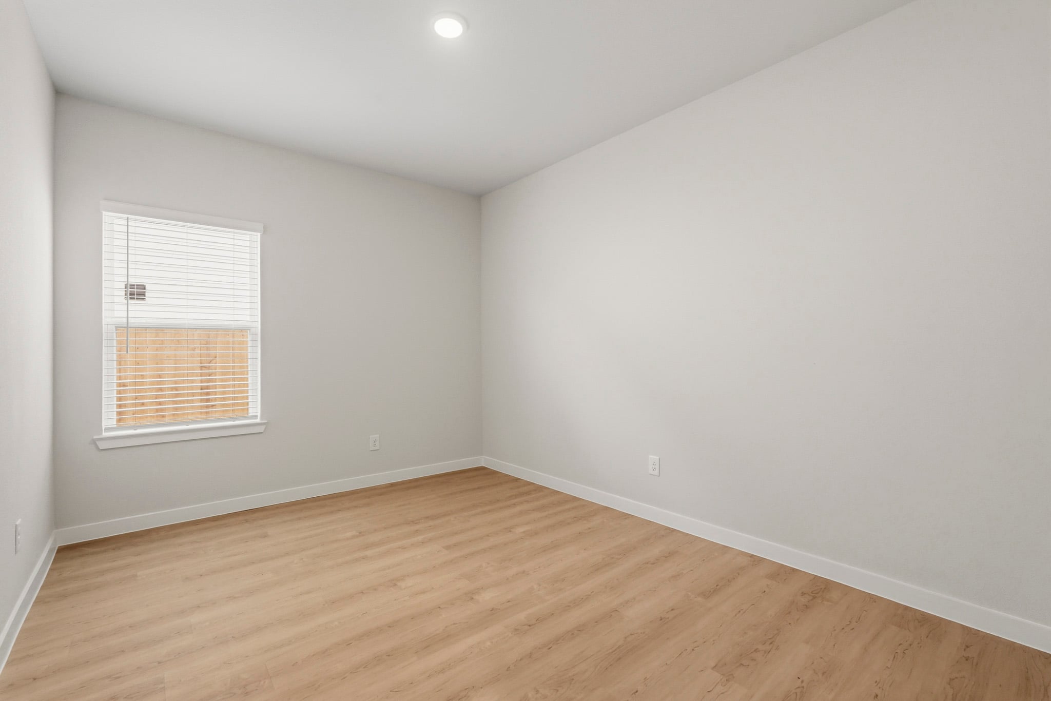 A room with a wood floor and a window.