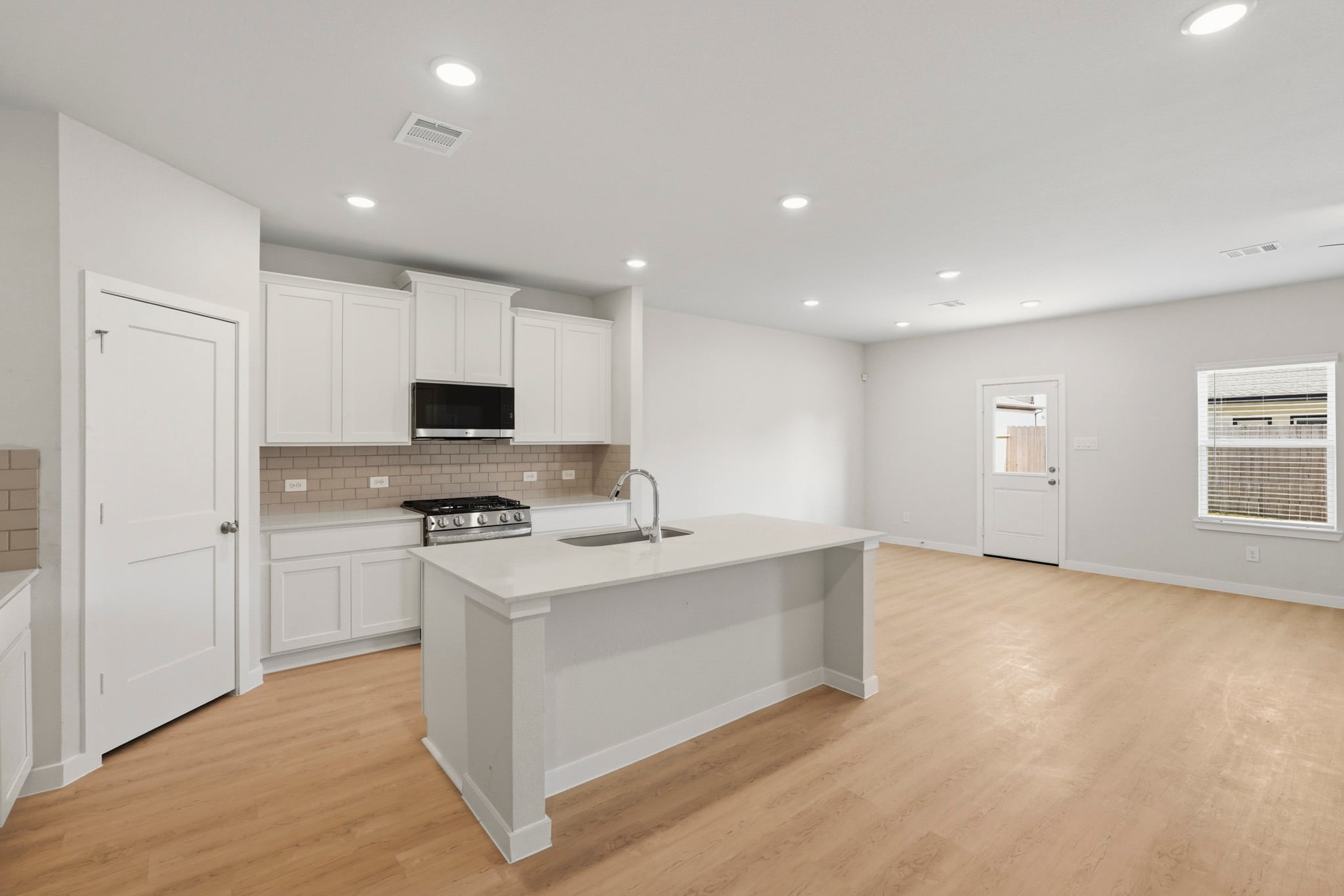 A kitchen with white cabinets.