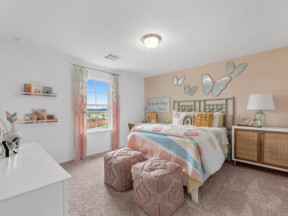 A bedroom with a bed and a chair.