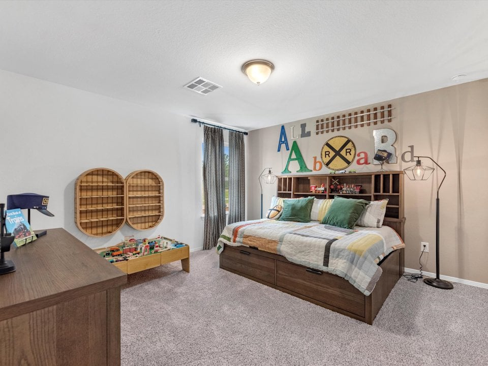 A bedroom with a bed and desk.