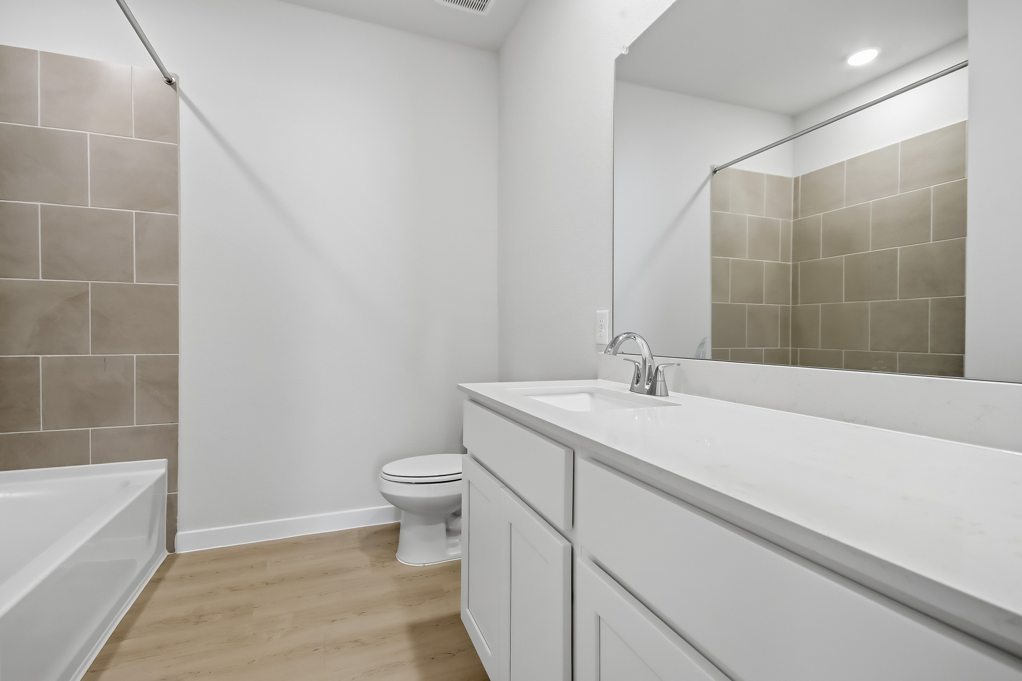 A bathroom with a tub sink and toilet.