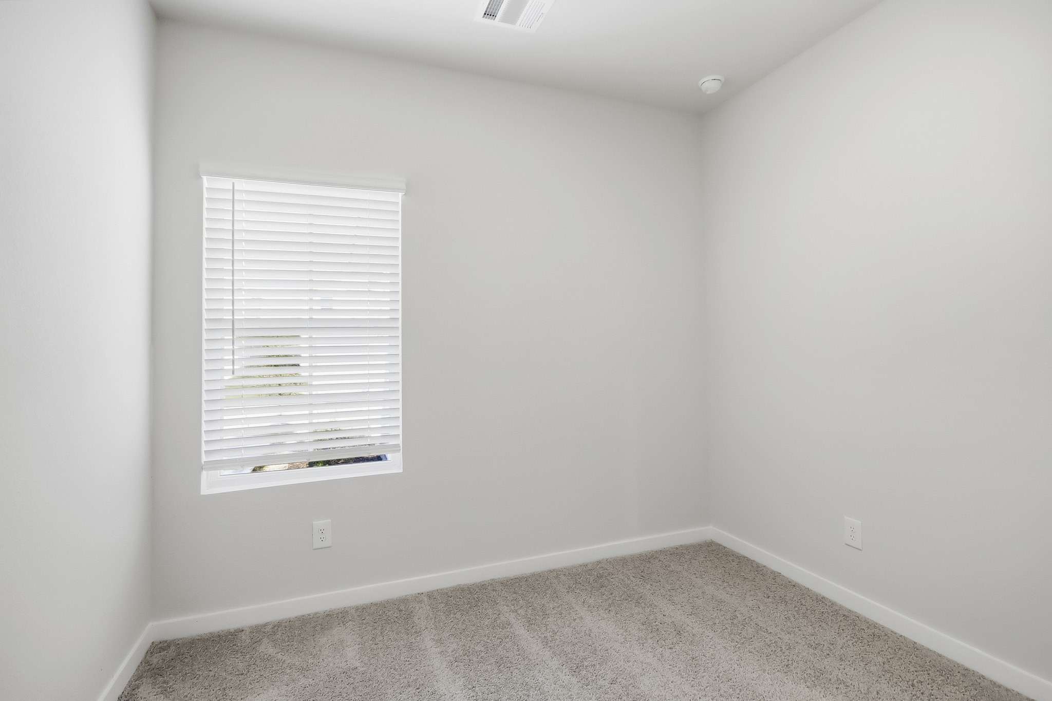 A white wall with a vent.