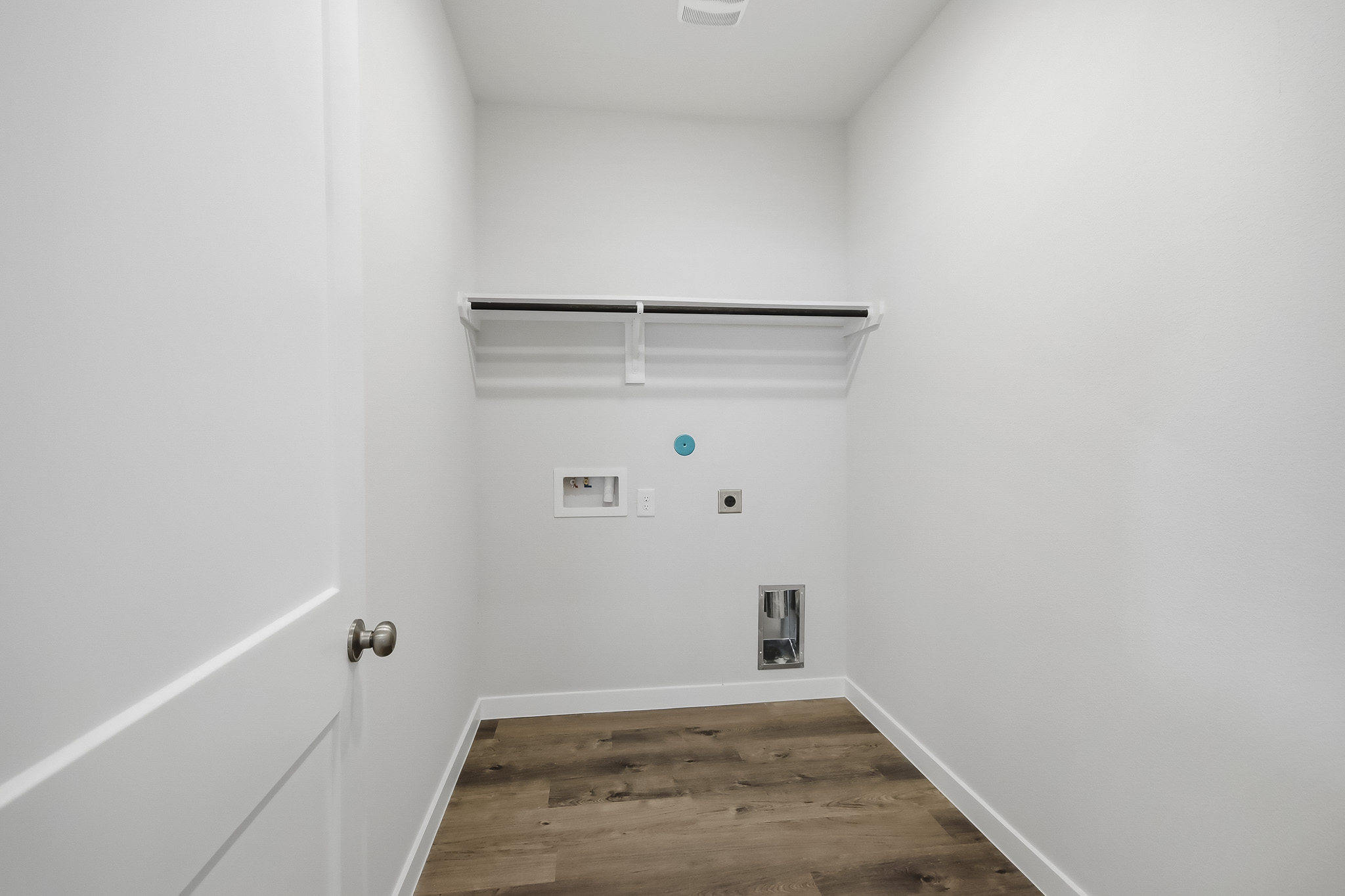A white room with a wood floor.