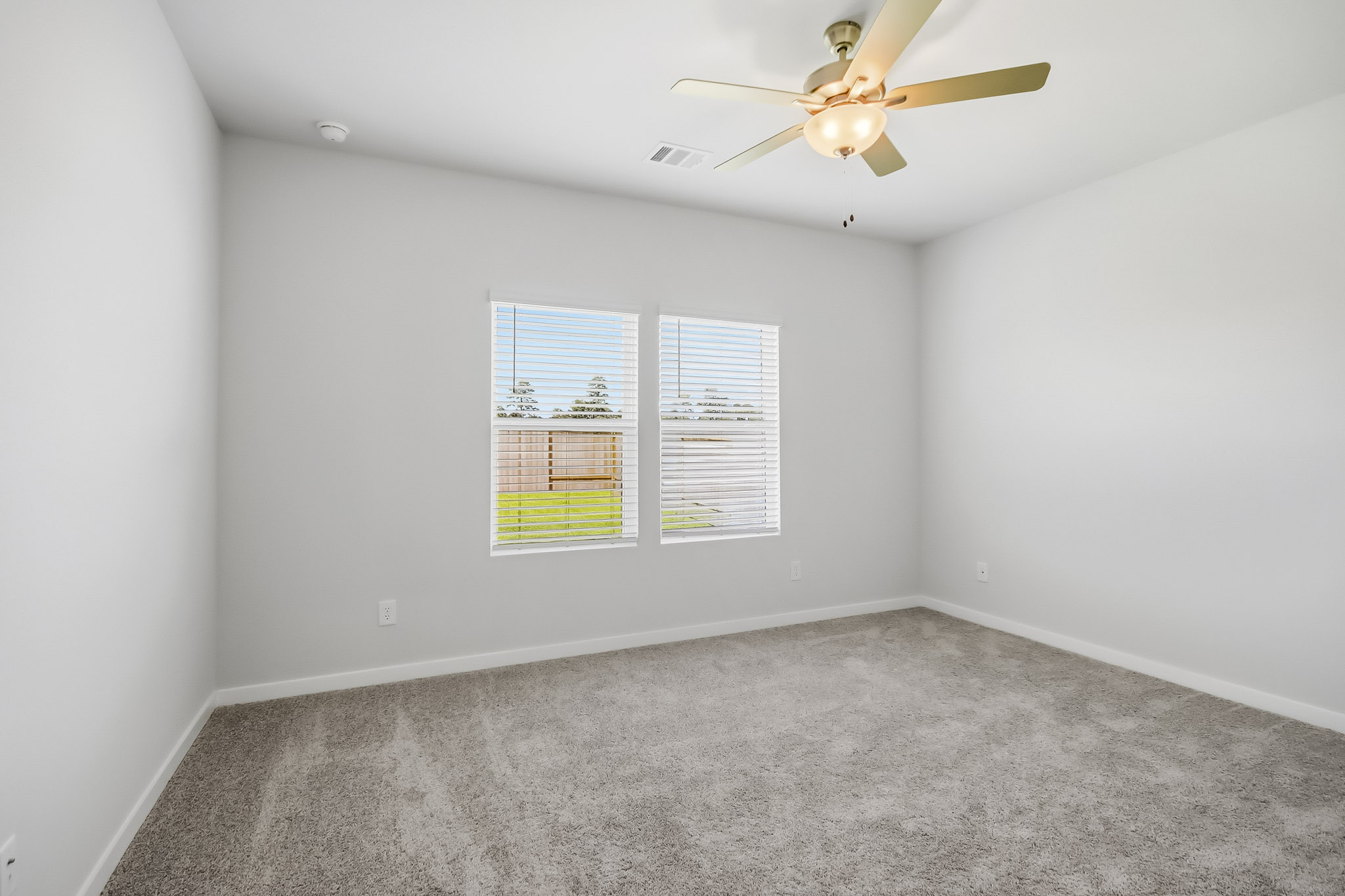 A room with a ceiling fan and a window.