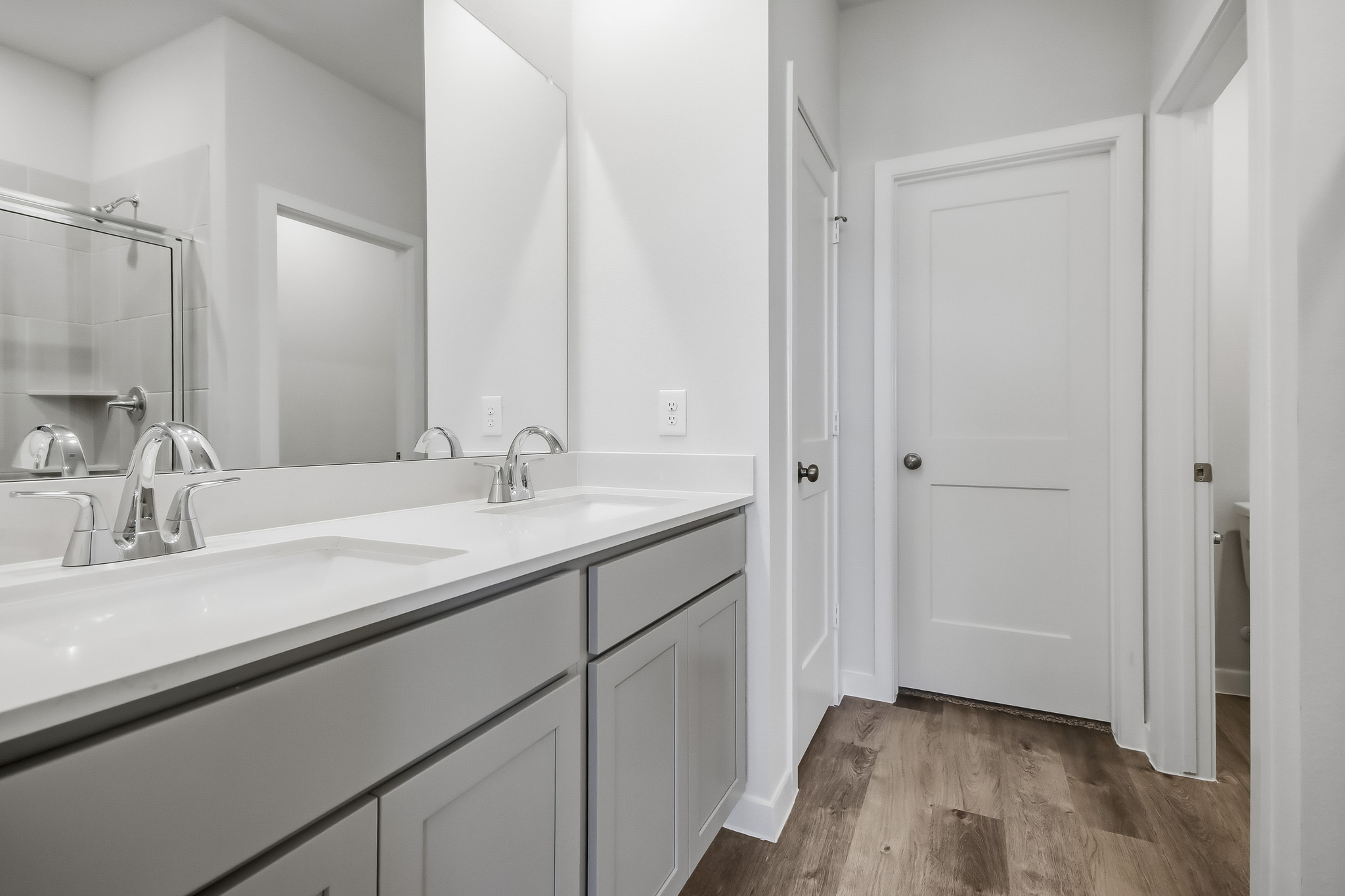 A bathroom with white cabinets.