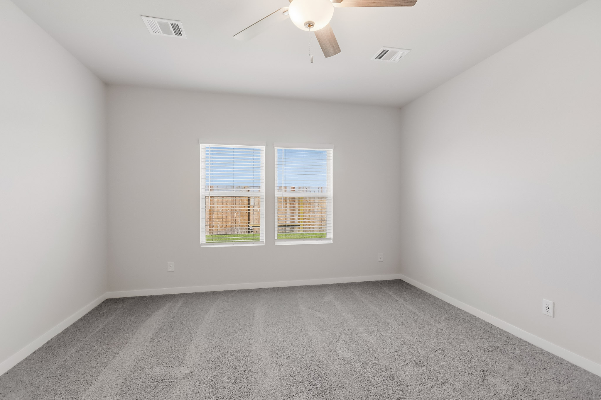 A room with a ceiling fan and a window.