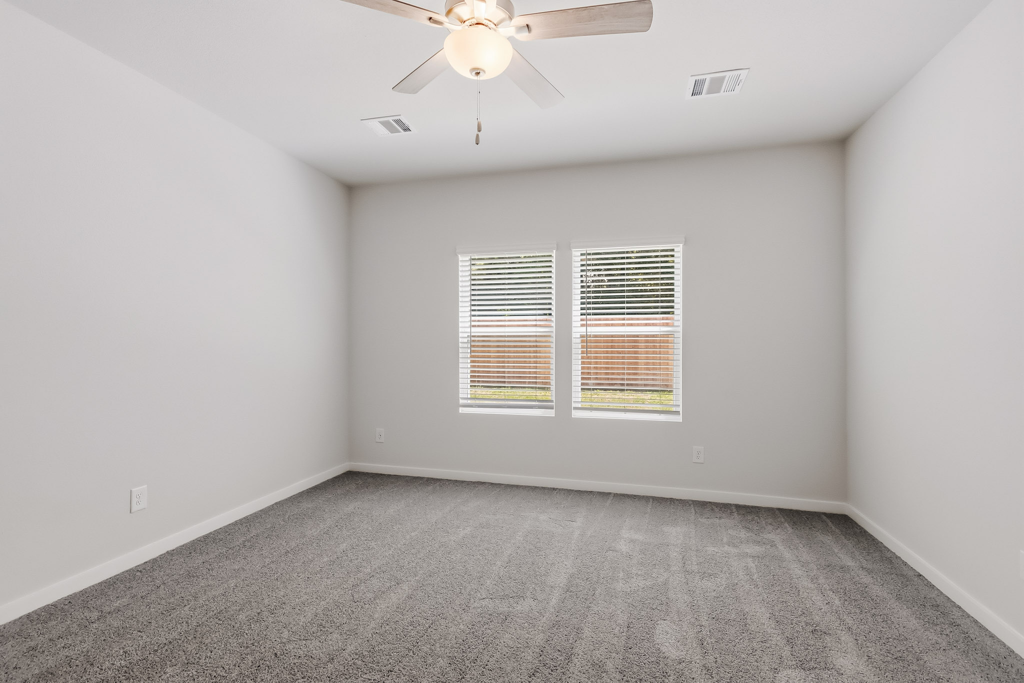 A room with a ceiling fan and a window.
