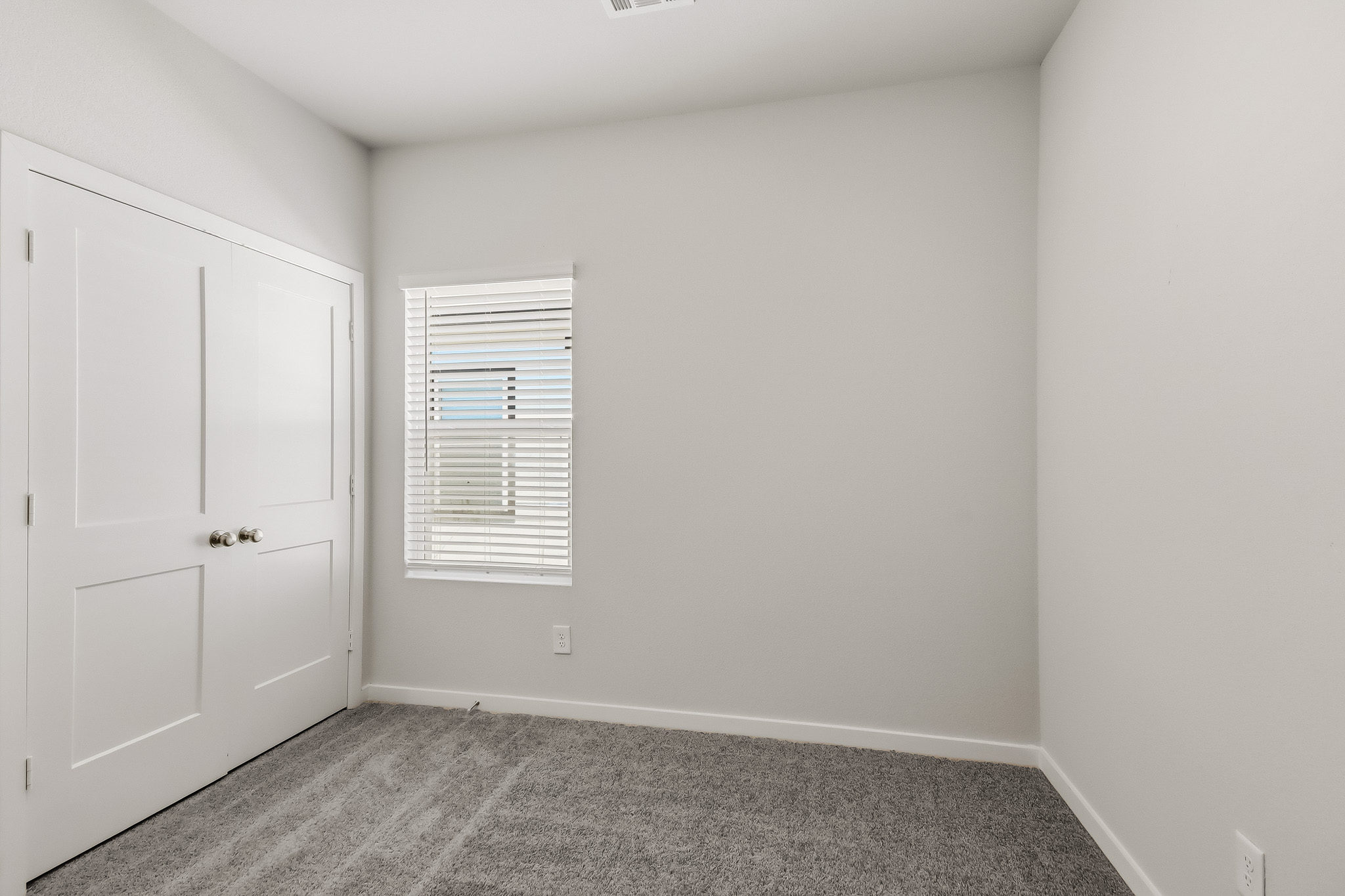 A room with white doors and a window.