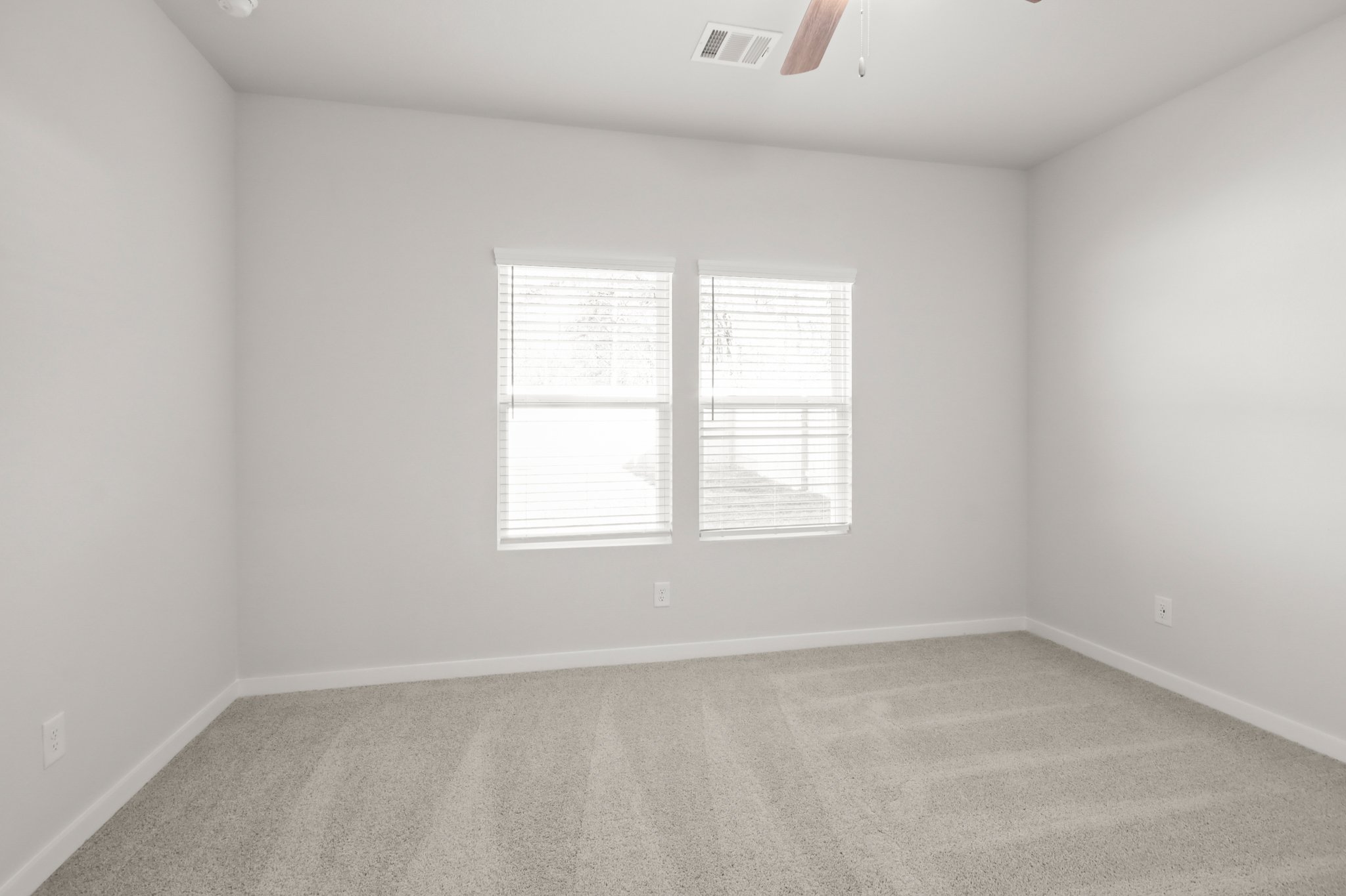 A room with a window and a carpet.
