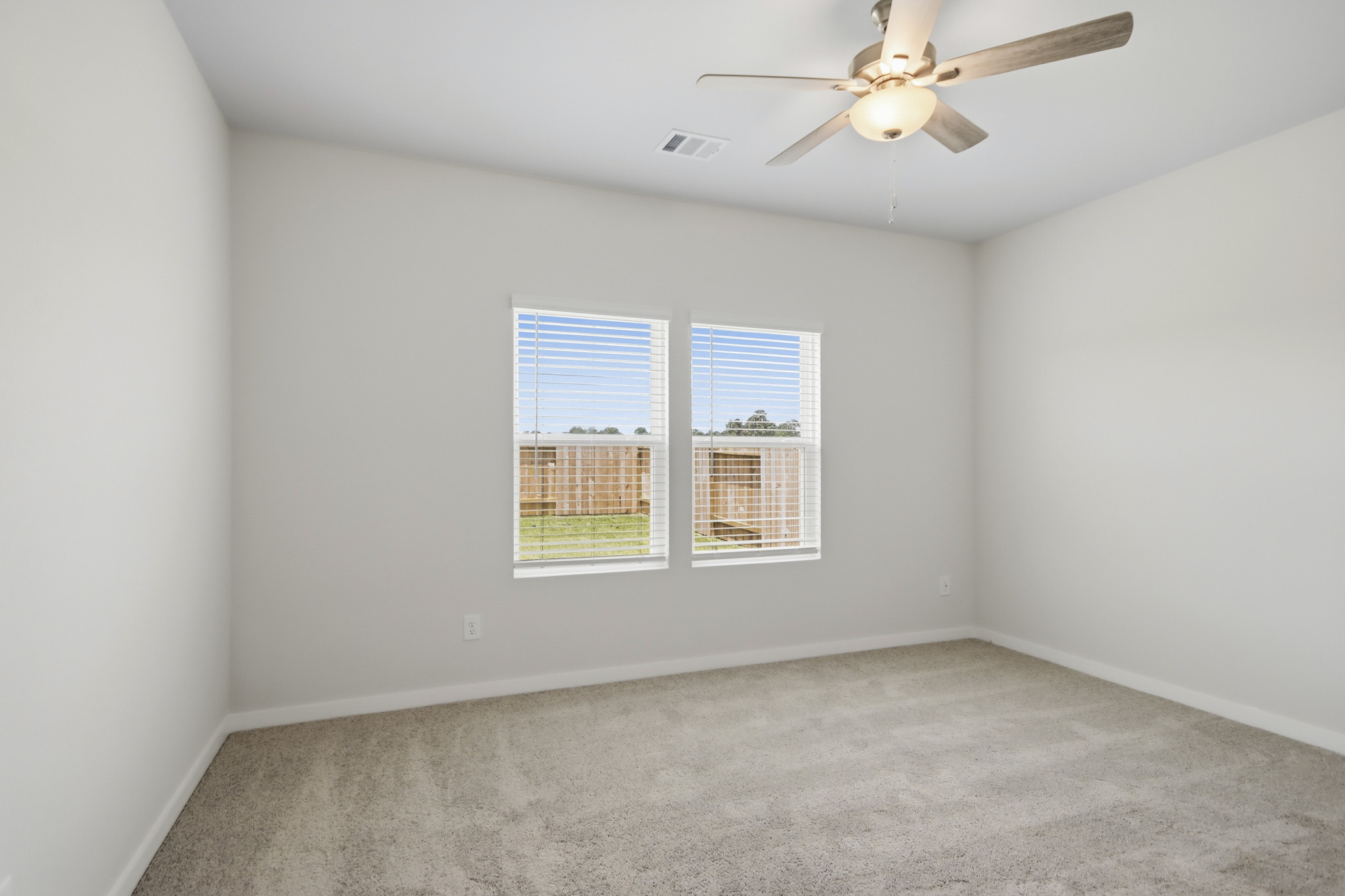A room with a ceiling fan and a window.