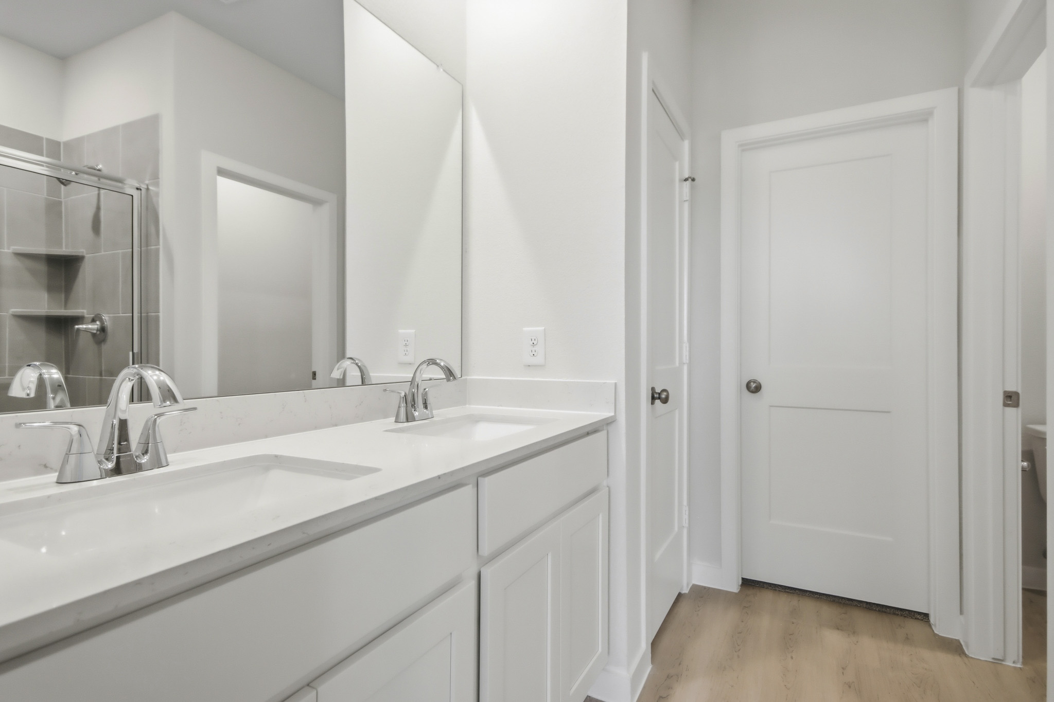 A bathroom with white cabinets.