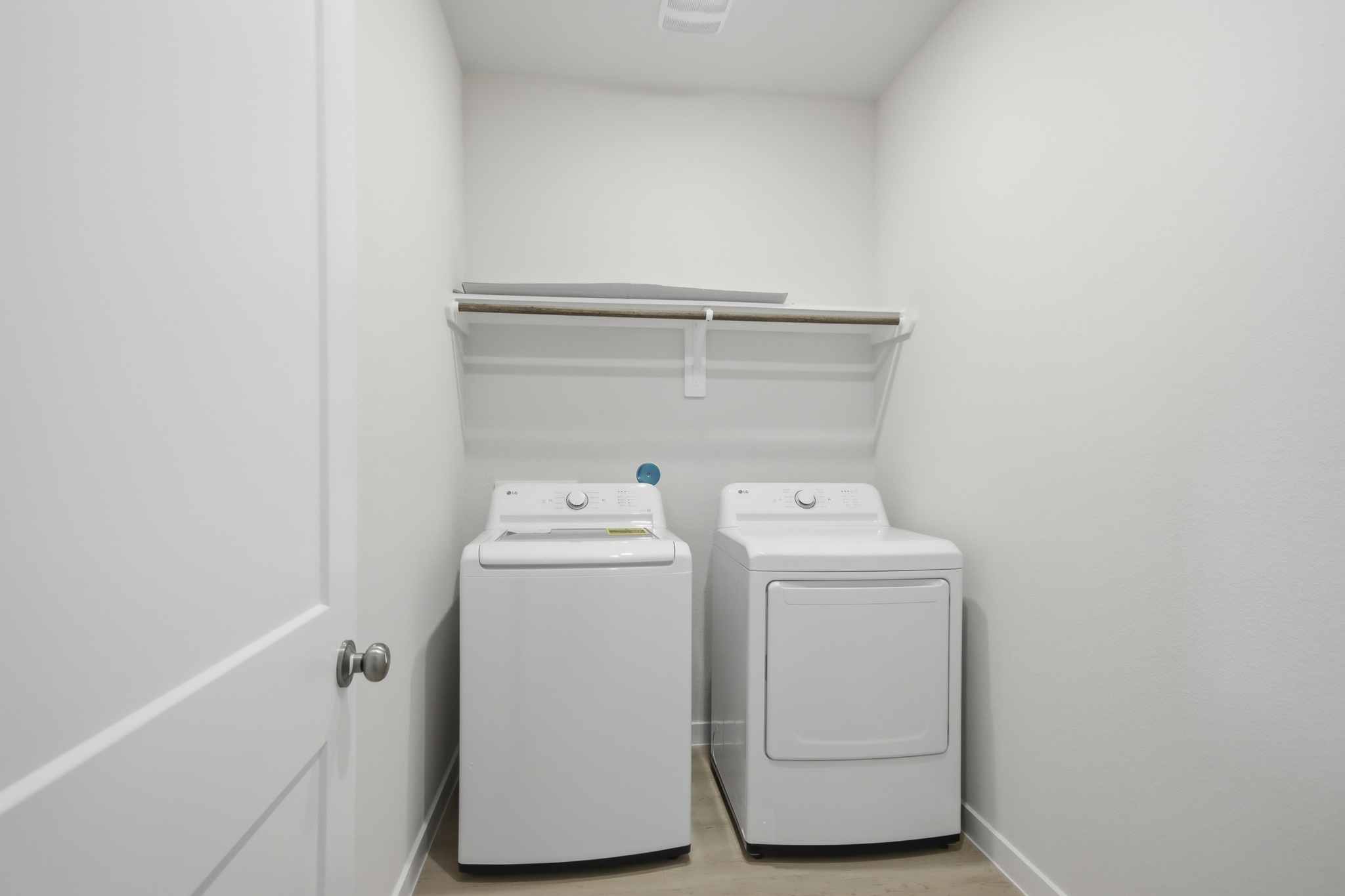 A white room with a white door and a white wall.
