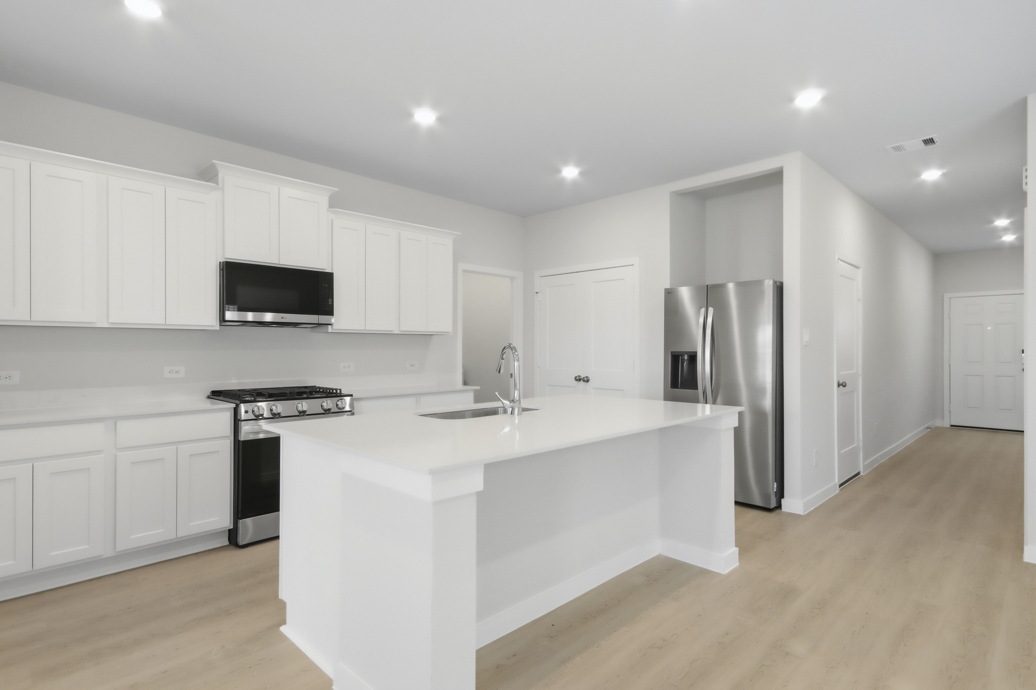 A kitchen with white cabinets.