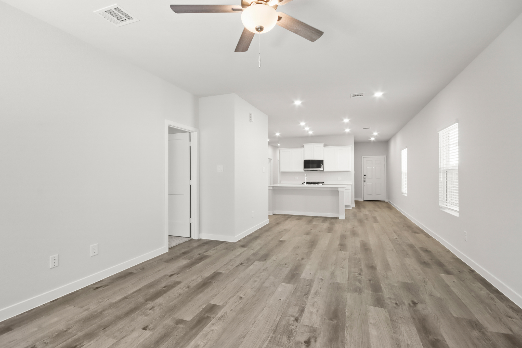 A room with a wood floor and a ceiling fan.
