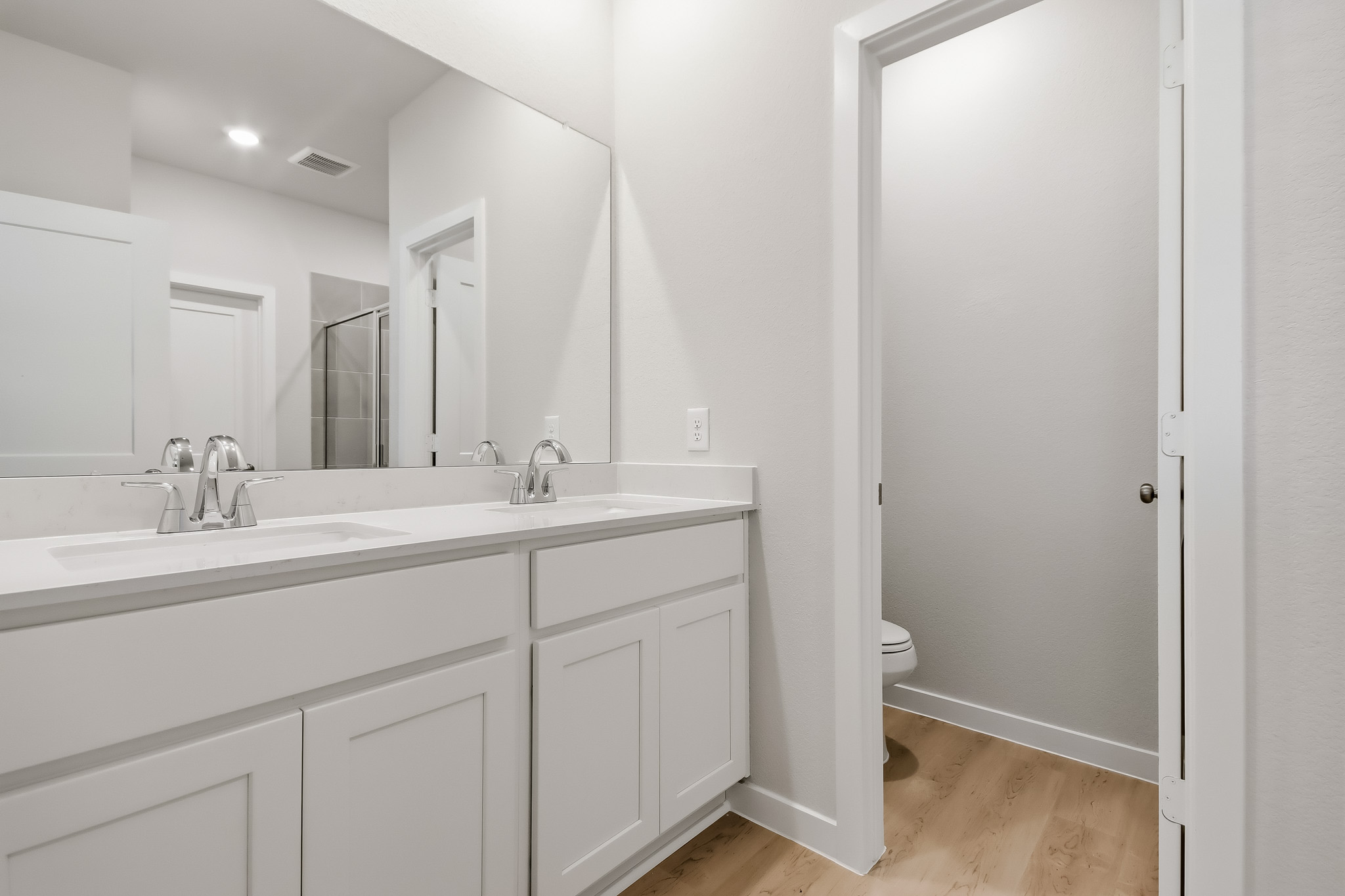 A bathroom with white cabinets.