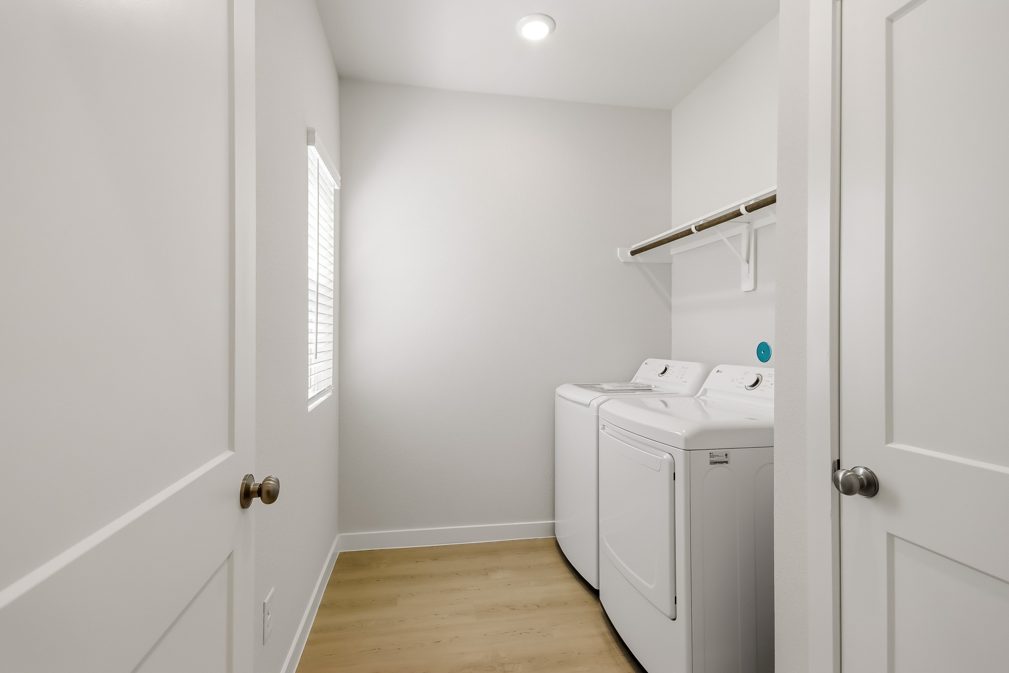 A room with white walls and a white washing machine.