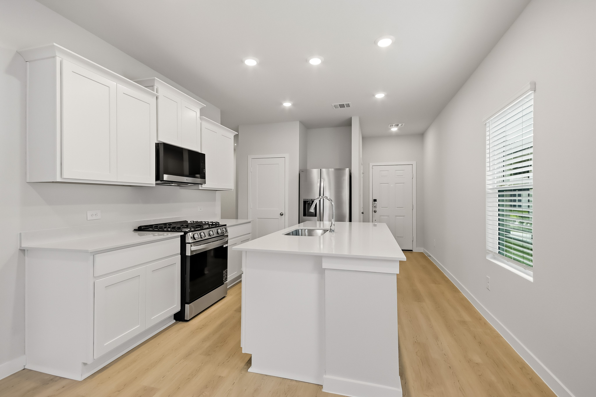 A kitchen with white cabinets.