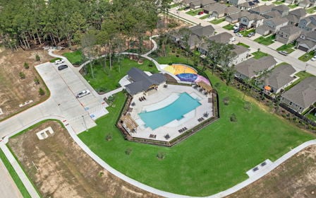 A large building with a green field.
