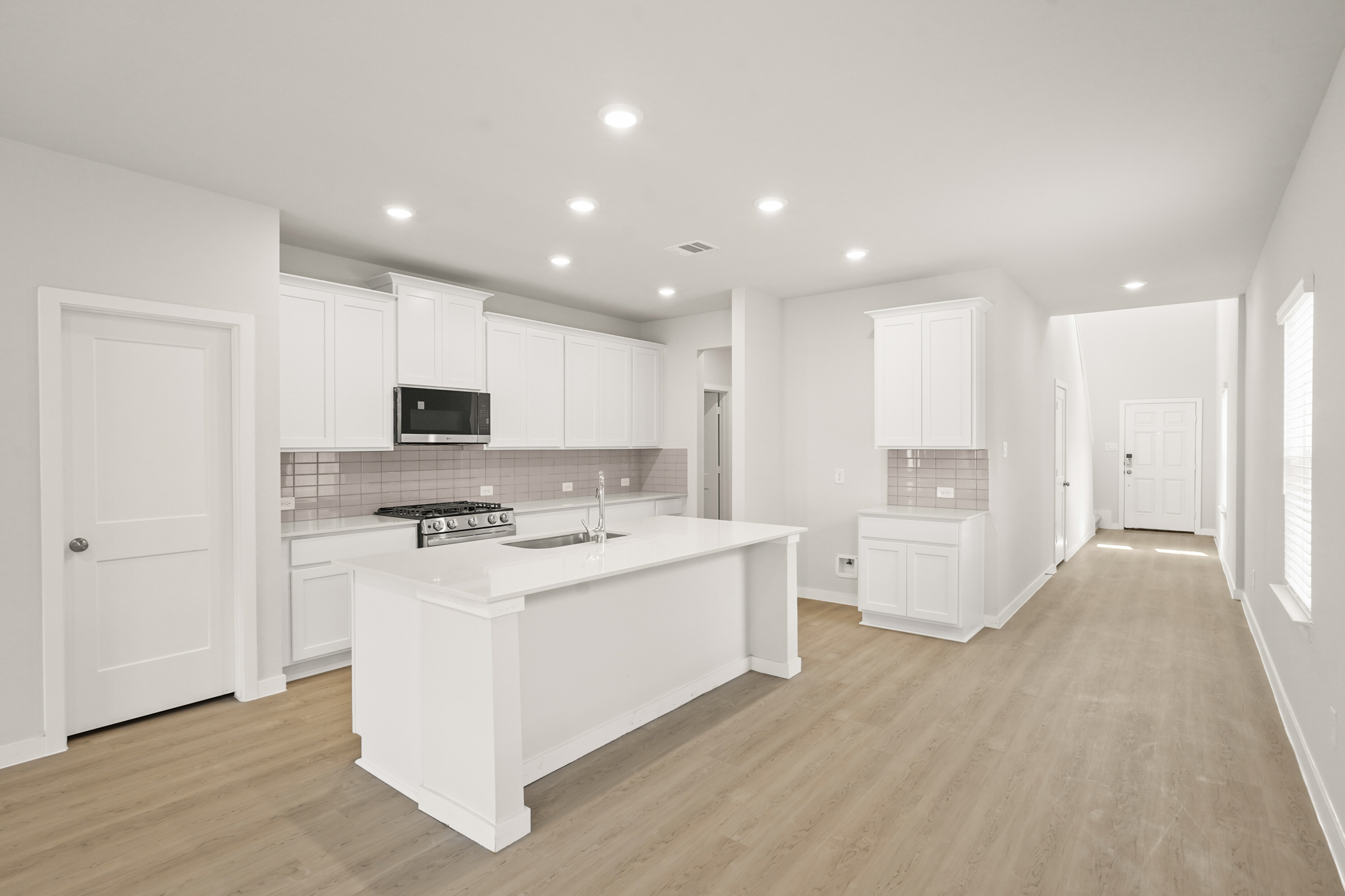 A kitchen with white cabinets.