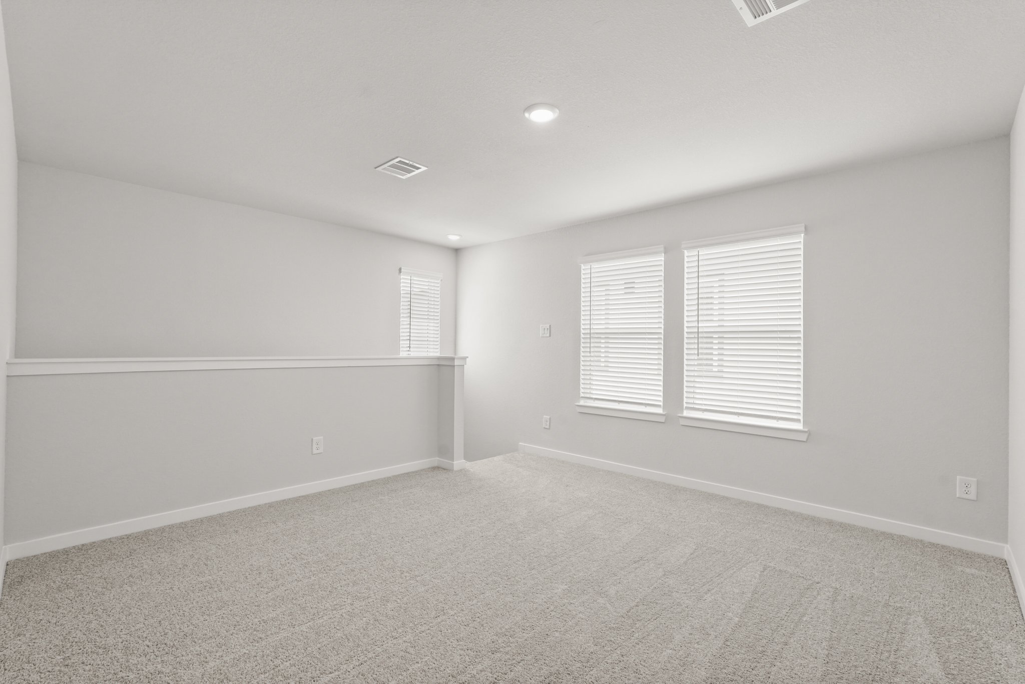 A room with a carpet and windows.