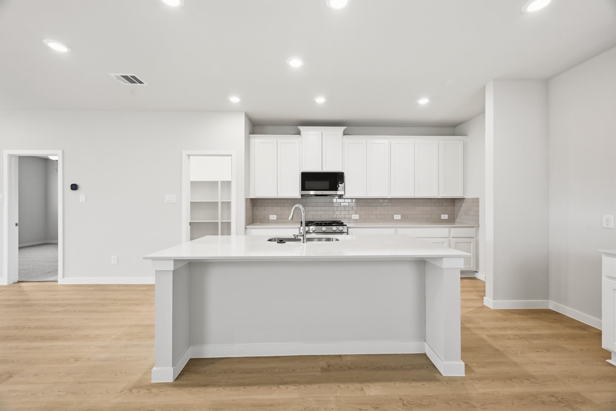 A kitchen with white cabinets.