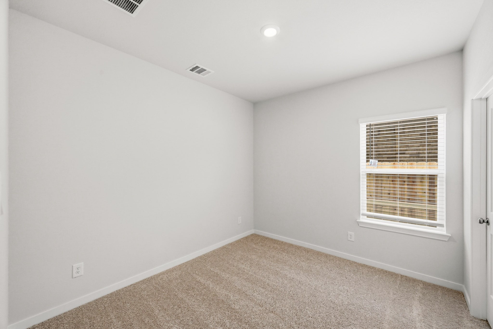 A room with a window and carpet.